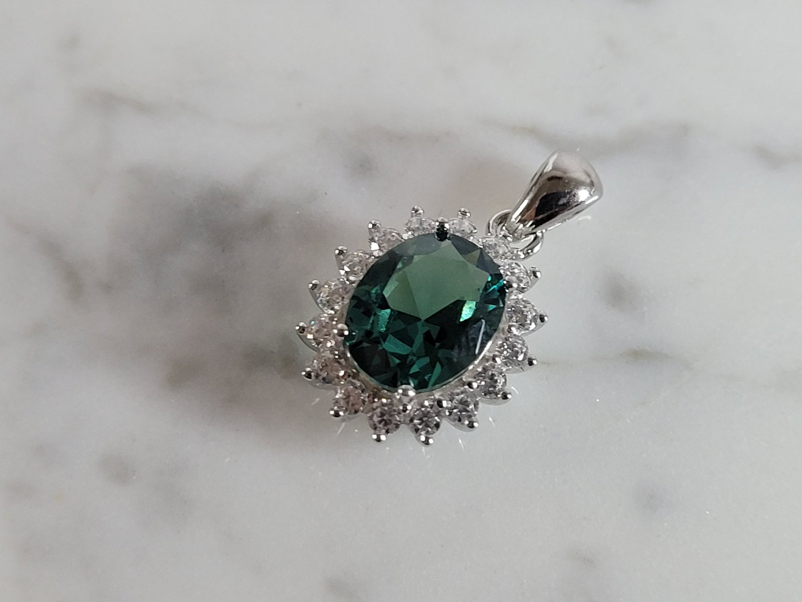 Womens Estate Sterling Silver Modernist CZ Pendant: A WOMENS ESTATE STERLING SILVER MODERNIST CZ PENDANT WITH AN EMERALD COLORED STONE. PENDANT WEIGHS 2.5g AND MEASURES 7/8" LONG BY 1/2" WIDE. MAKES A GREAT GIFT FOR THAT SOMEONE SPECIAL. ANY QUESTIONS,