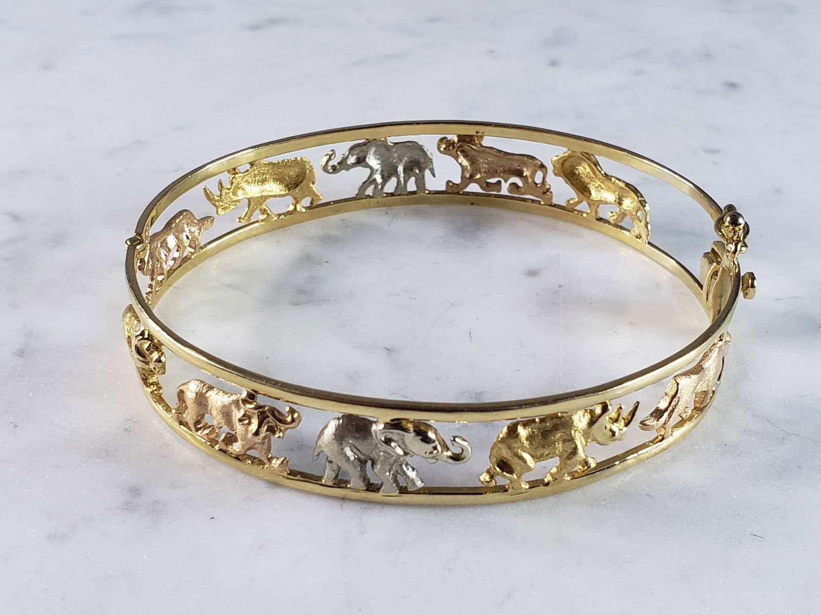 Womens Vintage Estate 18K Mixed Gold Noahs Ark Bangle Bracelet: A WOMENS VINTAGE ESTATE 18K MIXED GOLD NOAHS ARK BANGLE BRACELET. THE TOTAL WEIGHT IS 29.6g, AND HAS AN INNER CIRCUMFERENCE 0F ABOUT 8" AND IS 1/2" WIDE. BRACELET IS MARKED "750" ALONG THE INSIDE EDGE