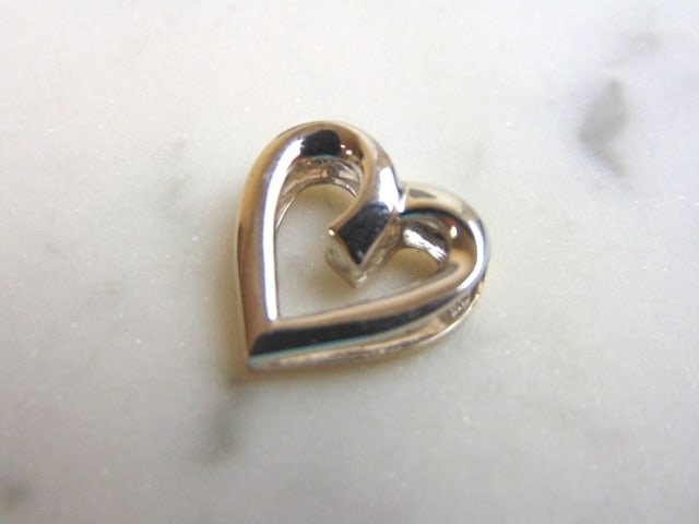 Womens Vintage Estate 10K Gold Reversible Heart Pendant: A WOMEN'S VINTAGE ESTATE 10K YELLOW & WHITE GOLD REVERSIBLE HEART PENDANT. PENDANT MEASURES 5/8" LONG BY 5/8" WIDE. TOTAL WEIGHT OF THE PENDANT IS 1.6g. WOULD MAKE A LOVELY GIFT FOR THAT SOMEONE SPECI