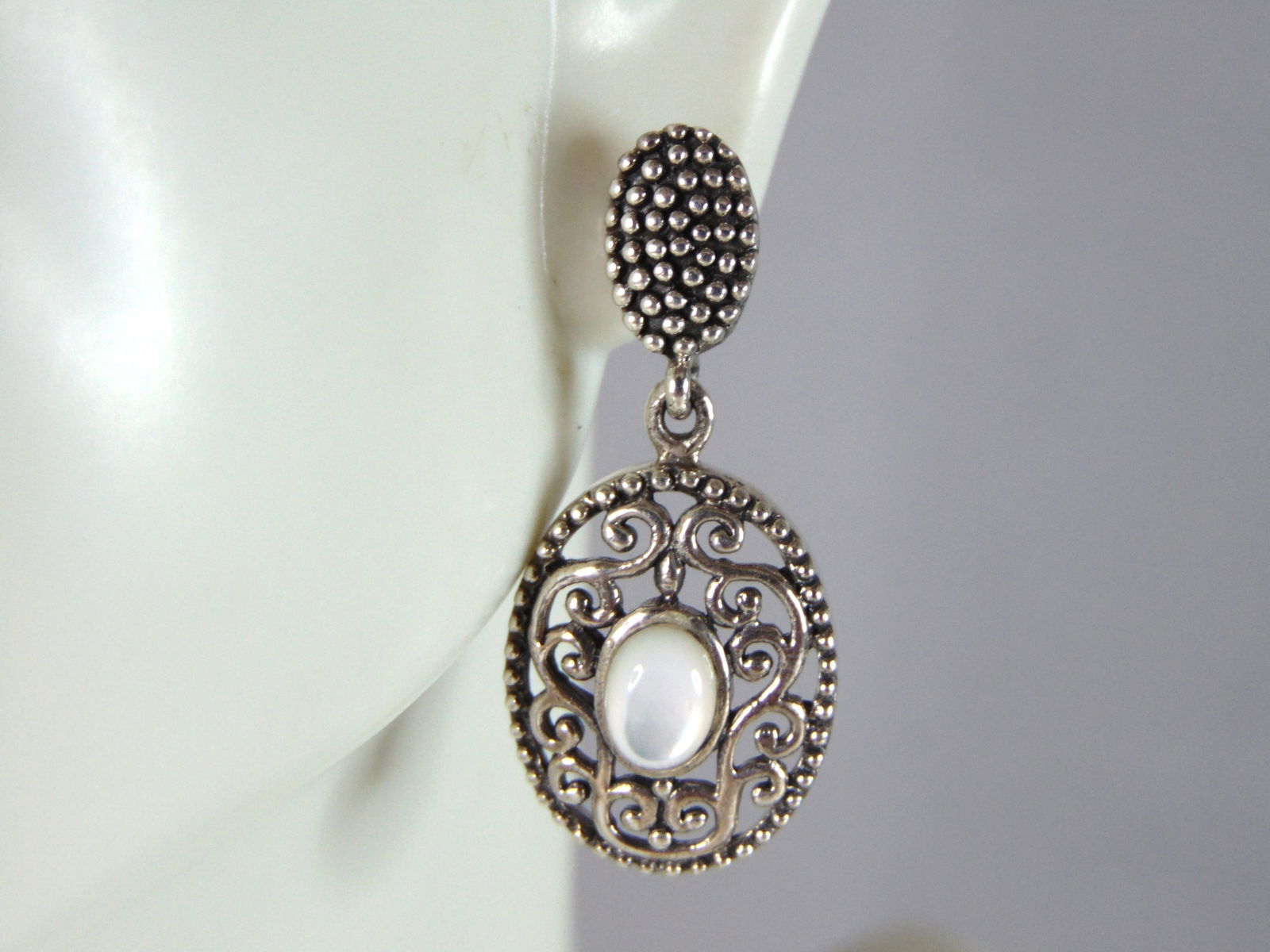 Womens Vintage Estate Sterling Silver M.O.P. Earrings: WOMENS VINTAGE ESTATE STERLING SILVER MOTHER OF PERAL EARRINGS THAT WEIGHS 5.4g AND MEASURES 1 1/4" LONG BY 1/2" WIDE. NOT SURE IF STONE IS NATURAL OR MAN MADE. ANY OTHER QUESTIONS, PLEASE DO NOT HESI