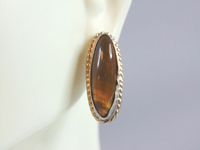 Womens Single Sterling Silver Tigers Eye Earring: SINGLE WOMENS STERLING SILVER TIGERS EYE EARRING THAT WEIGHS 3.5g AND MEASURES 1" LONG BY 3/8" WIDE. NOT SURE IF STONE IS REAL OR MAN MADE. ANY OTHER QUESTIONS, PLEASE DO NOT HESITATE TO ASK. BE SURE