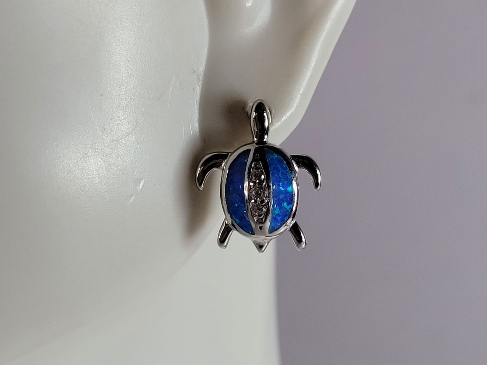 Womens Sterling Silver Blue Opal Sea Turtle Earrings: A PAIR OF WOMENS STERLING SILVER BLUE OPAL COLORED SEA TURTLE EARRINGS THAT WEIGH 4.3g AND MEASURES 1/2" LONG BY 1/2" WIDE. NOT SURE IF STONES ARE REAL OR MAN MADE. ANY OTHER QUESTIONS, PLEASE DO NOT