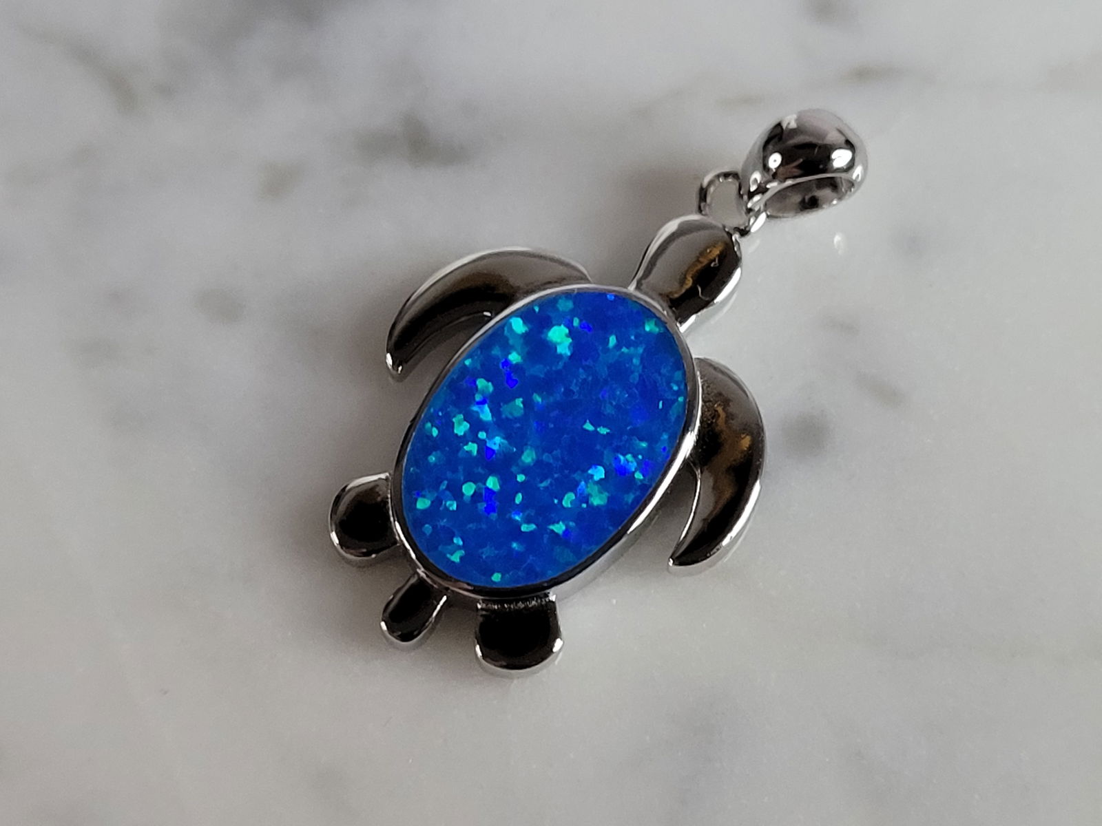 Womens Sterling Silver Blue Opal Sea Turtle Pendant: A WOMENS STERLING SILVER BLUE OPAL SEA TURTLE PENDANT. NOT SURE IF STONES ARE REAL OR MAN MADE. THE PENDANT WEIGHS 4.1g AND MEASURES 1 1/4" LONG BY 3/4" WIDE. MAKES A GREAT GIFT FOR THAT SOMEONE SPECI