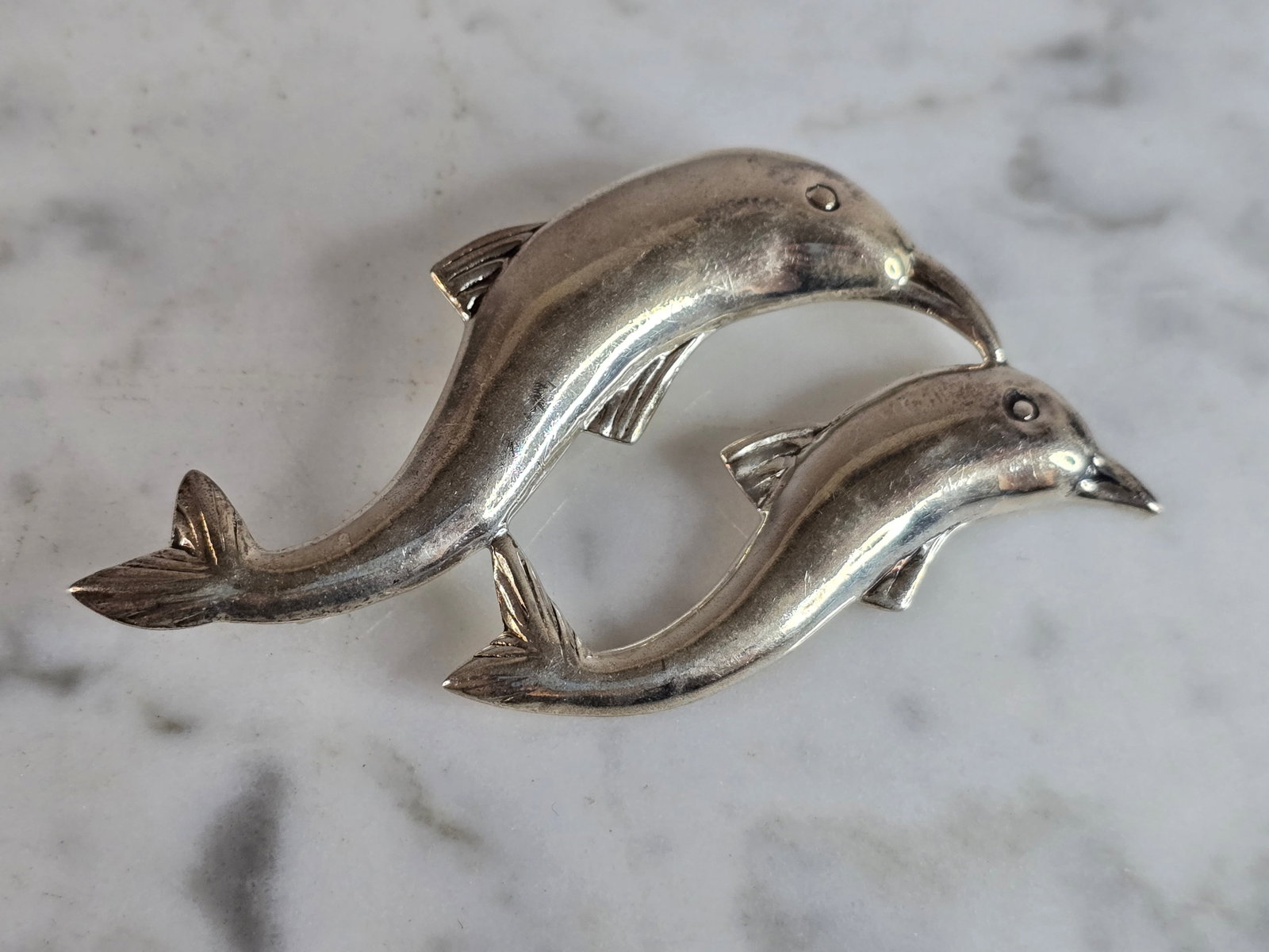 Womens Vintage Estate Sterling Silver Dolphin Brooch: A WOMENS VINTAGE ESTATE STERLING SILVER DOLPHIN BROOCH. THE TOTAL WEIGHT OF THE BROOCH IS 9.7g. THE BROOCH MEASURES 2 3/8" LONG BY 1 3/8" WIDE. BROOCH IS STAMPED "925". MAKES A GREAT GIFT FOR THAT SPE