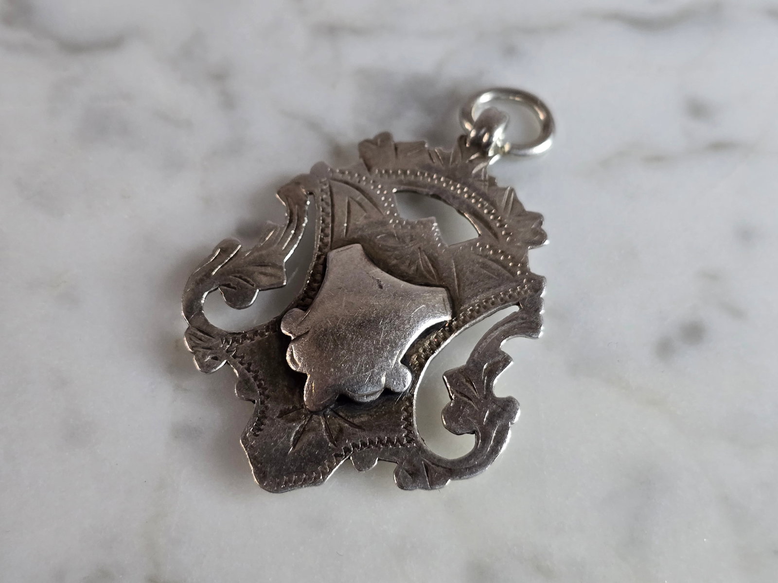 Antique English Sterling Silver Watch Fob Medal: AN ANTIQUE ENGLISH STERLING SILVER WATCH FOB MEDAL THAT IS BELIEVED TO BE MADE BY HARDY BROS, 1915. FOB WEIGHS 6.2g, AND MEASURES 1 3/4" BY 1 1/8". THIS WOULD MAKE A NICE GIFT FOR THAT SOMEONE SPECIAL