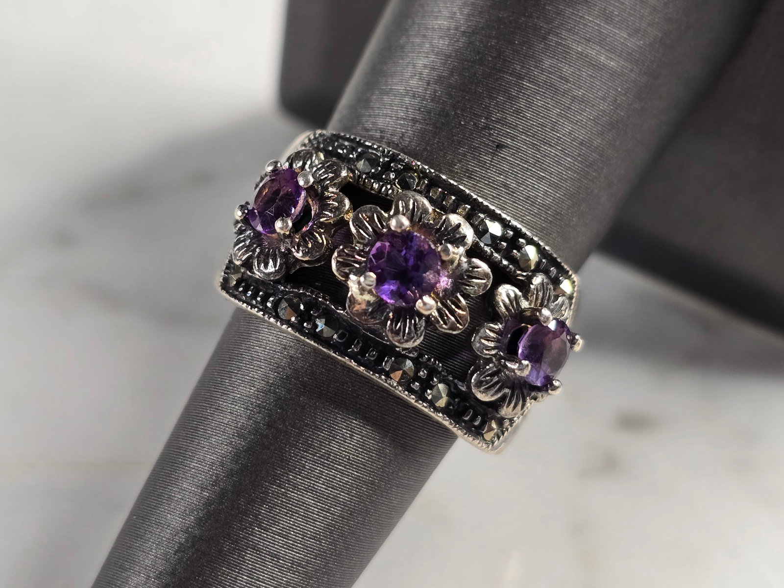 Womens Vintage Estate Sterling Silver Amethyst Flower Ring: A WOMENS VINTAGE ESTATE STERLING SILVER AMETHYST FLOWER RING. THE RING WEIGHS 8.5g, AND IS A SIZE 7.0. THE WIDTH OF THE RING IS 1/2". NOT SURE IF STONE IS REAL OR MAN MADE. ANY QUESTIONS PLEASE DO NOT