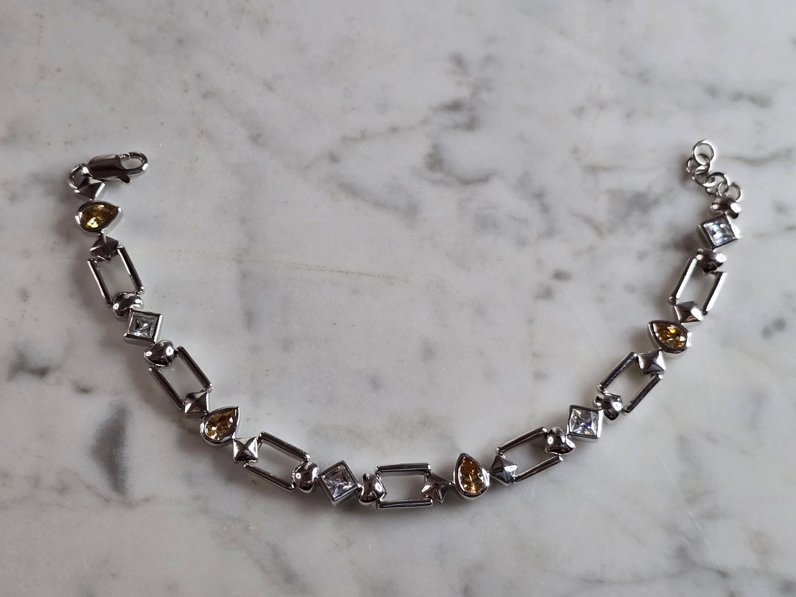 Womens Vintage Estate Sterling Silver Modernist Citrine Bracelet: A WOMENS VINTAGE ESTATE STERLING SILVER MODERNIST TENNIS BRACELET WITH CITRINE COLORED STONES. THE BRACELET MEASURES 7 3/4" LONG BY 1/4" WIDE, AND WEIGHS 16.7g. NOT SURE IF THE STONES ARE NATURAL OR M