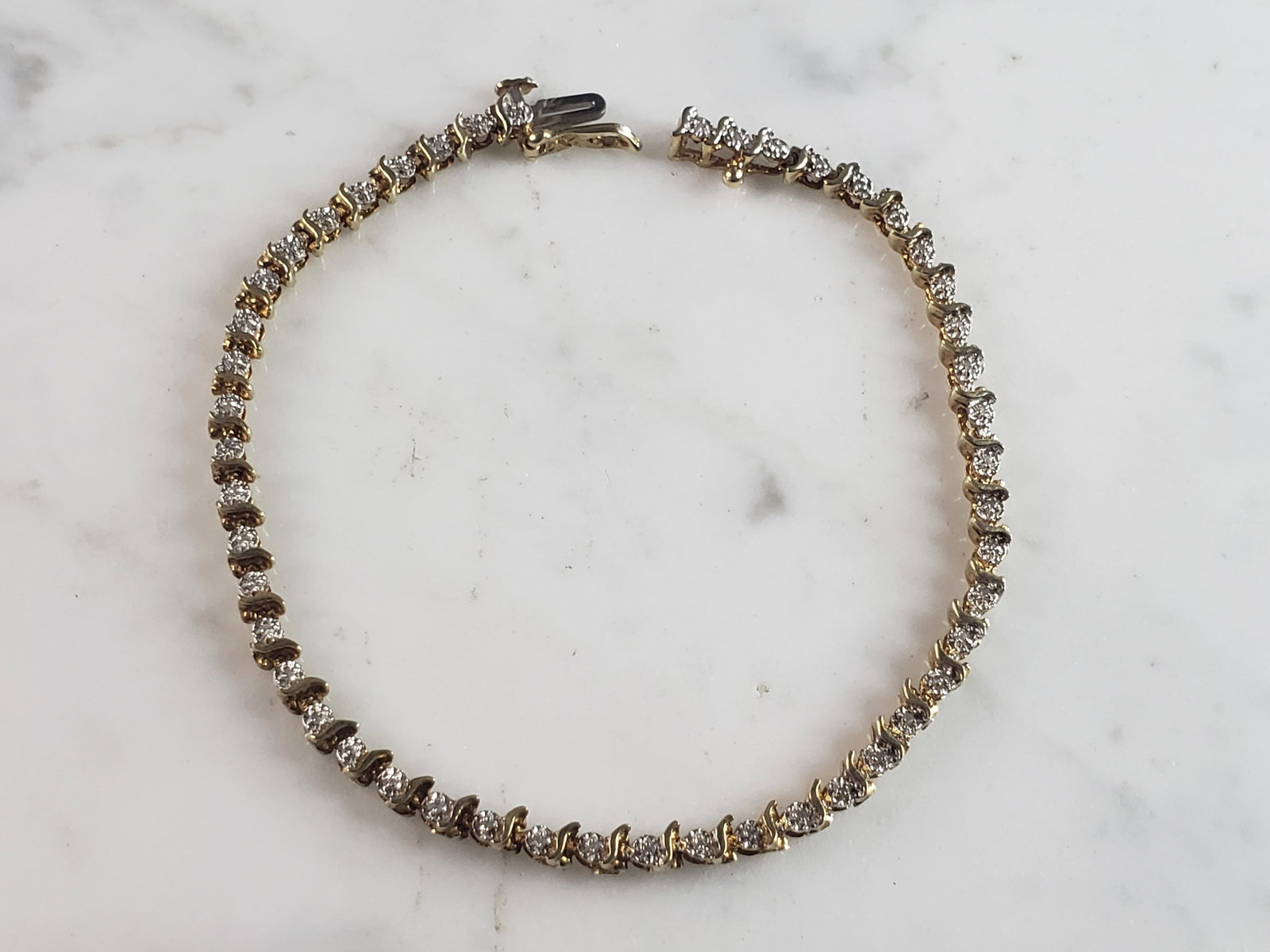 Womens Vintage Estate 10K Gold Diamond Tennis Bracelet: A WOMENS VINTAGE ESTATE 10K WOMENS TENNIS BRACELET WITH ABOUT .48cts. THE BRACELET MEASURES 7 1/4" LONG BY 1/8" WIDE. AND WEIGHS 7.3g. WOULD MAKE A GREAT GIFT FOR THAT SPECIAL SOMEONE. ANY QUESTIONS P