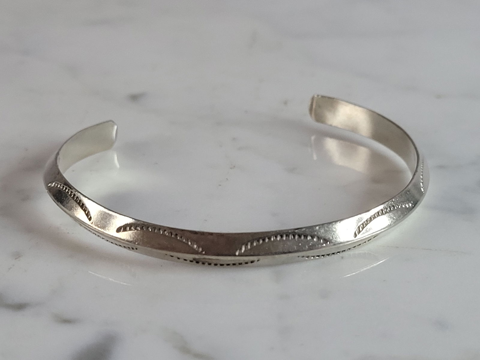 Vintage Estate Sterling Silver Southwestern Design Cuff Bracelet: A VINTAGE ESTATE STERLING SILVER SOUTHWESTERN DESIGN CUFF BRACELET. THE BRACELET WEIGHS 11.2g AND MEASURES ABOUT 1/4" WIDE WITH AN INNER CIRCUMFERENCE OF 6 3/4". BRACELET IS NOT MARKED BUT IT HAS BEEN