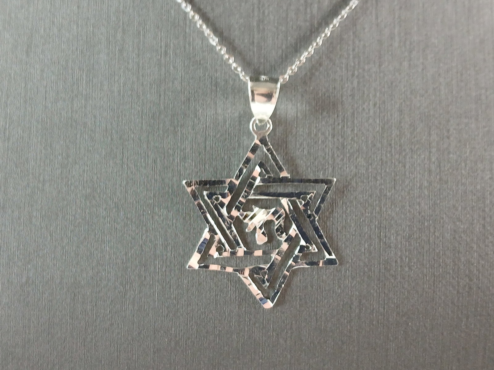 Sterling Silver Jewish Judaica Star of David Chai Pendant Necklace: A STERLING SILVER STAR OF DAVID CHAI PENDANT WITH NECKLACE. THE PENDANT WITH NECKLACE WEIGHS 3.1g. THE NECKLACE MEASURES 18" LONG, AND IS ADJUSTABLE TO 16" LONG. THE PENDANT MEASURES 1 1/2" LONG BY 1"