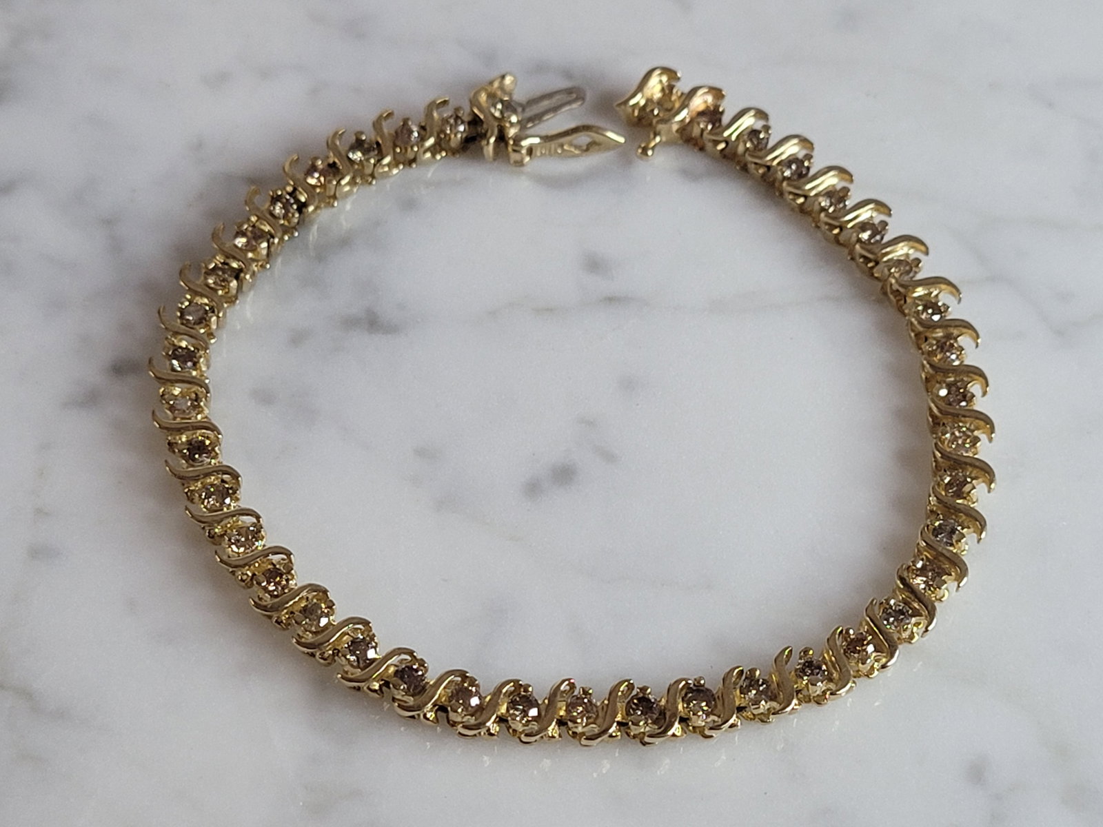 Womens Vintage Estate 14K Gold Diamond Tennis Bracelet w/ 2.0cts: A LOVELY WOMENS VINTAGE ESTATE 14K YELLOW GOLD TENNIS BRACELET WITH ABOUT 2.0cts OF DIAMONDS. THE BRACELET WEIGHS 12.4g AND MEASURES 7 1/2" LONG, BY 3/16" WIDE. MISSING A TINY DIAMOND AT ONE END. EASY