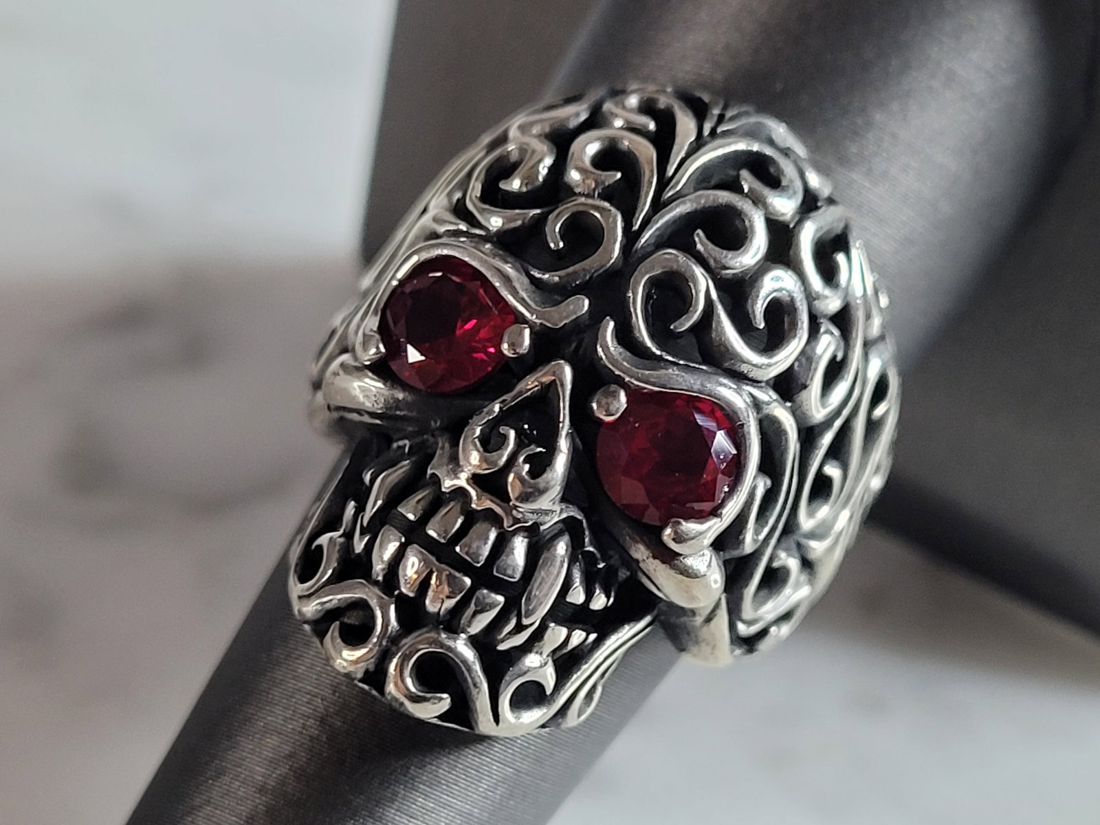 Mens Sterling Silver Ruby Eyed Skull Ring: A MENS STERLING SILVER RUBY EYED SKULL RING. THE TOTAL WEIGHT IS 13.6g, AND IS A SIZE 9.0. THE LENGTH OF THE RING FACE IS 1 1/8". STONES TESTED RUBY ON OUR PRESIDIUM GEM TESTER. THIS RING WOULD MAKE A