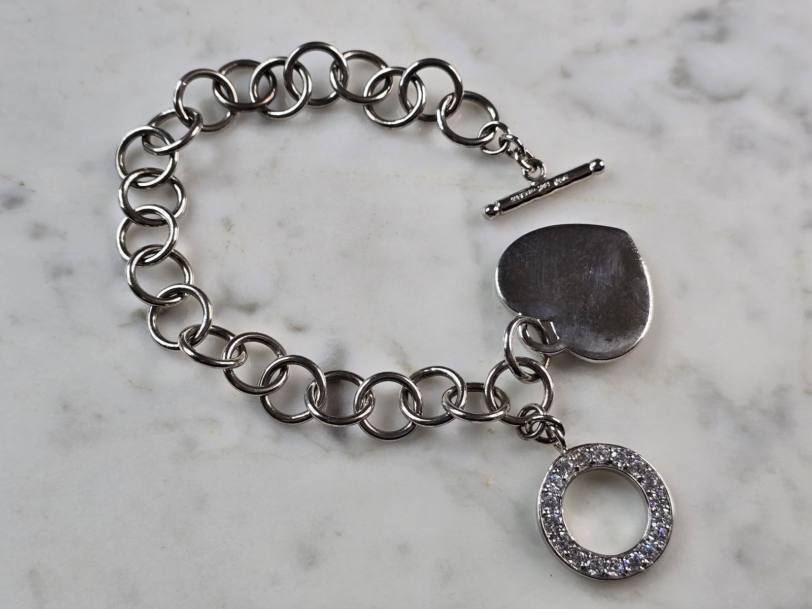 Womens Vintage Estate Sterling Silver Heart Charm Bracelet: A WOMENS VINTAGE ESTATE STERLING SILVER HEART CHARM CZ BRACELET. BRACELET MEASURES 8" LONG BY 3/8" WIDE AND WEIGHS 23.6g. THIS WOULD MAKE A LOVELY GIFT FOR THAT SOMEONE SPECIAL. ANY QUESTIONS, PLEASE
