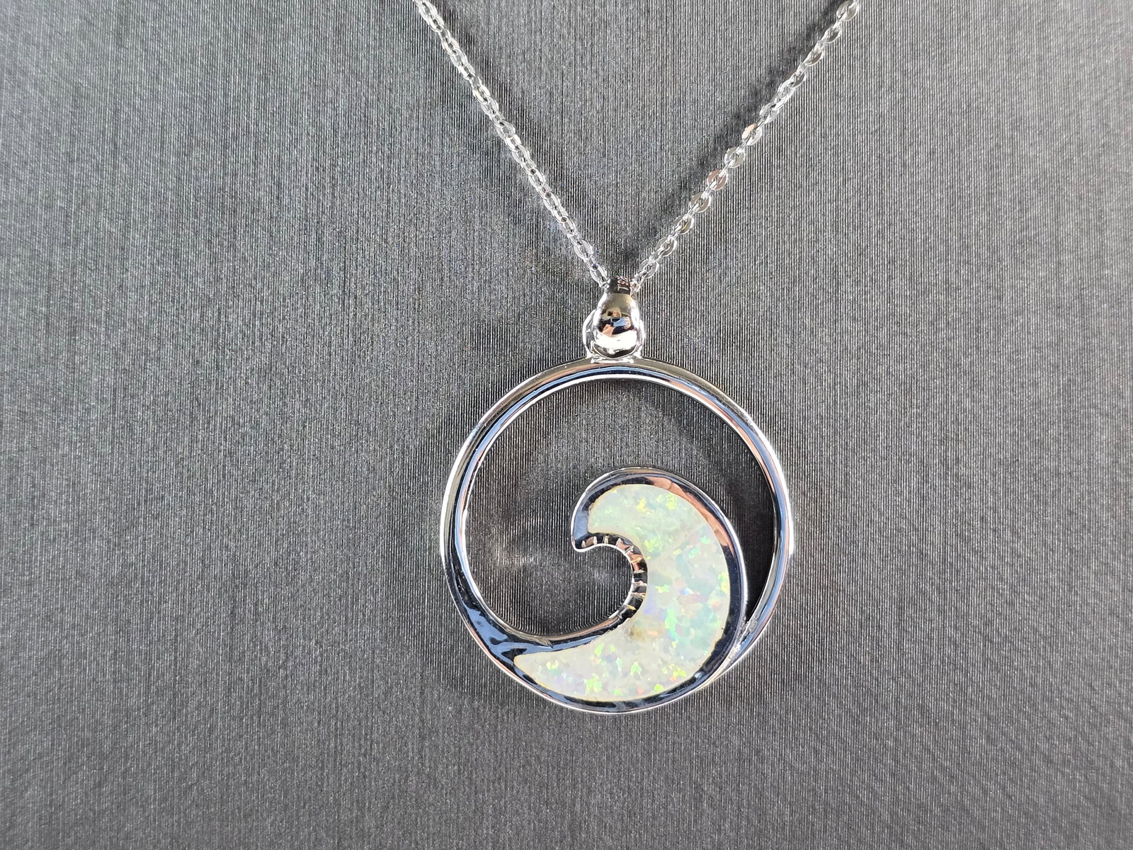 Womens Sterling Silver Opal Wave Pendant Necklace: A WOMENS STERLING SILVER OPAL WAVE PENDANT. THE PENDANT WITH NECKLACE WEIGHS 6.6g. THE PENDANT MEASURES 1 1/4" LONG BY 1" WIDE, AND THE NECKLACE MEASURES 18" LONG, ADJUSTABLE TO 16". NOT SURE IF STONE