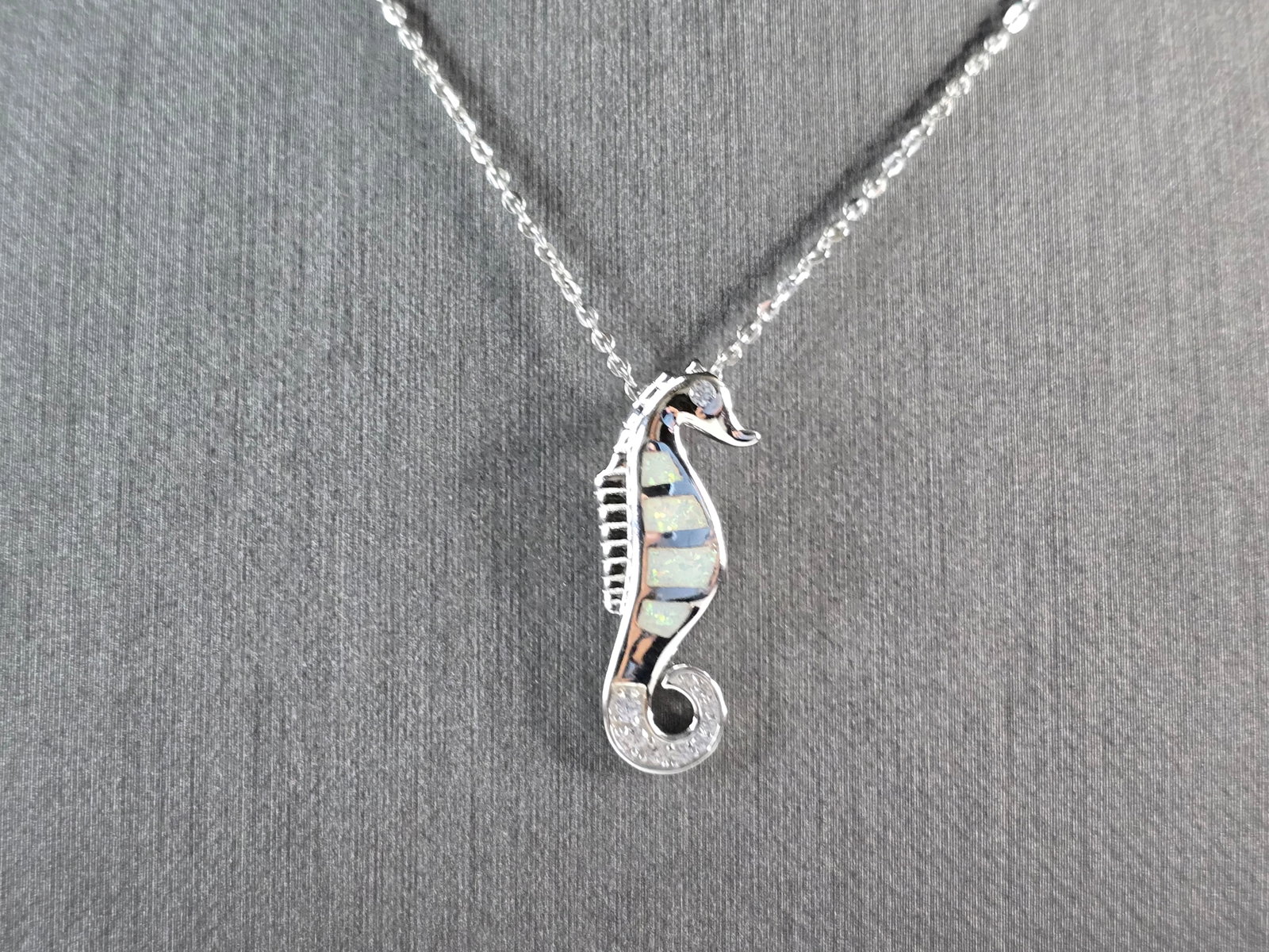 Womens Sterling Silver Opal Seahorse Pendant Necklace: A WOMENS STERLING SILVER OPAL SEAHORSE PENDANT. THE PENDANT WITH NECKLACE WEIGHS 4.4g. THE PENDANT MEASURES 1" LONG BY 3/8" WIDE. THE NECKLACE MEASURES 18" LONG AND IS ADJUSTABLE TO 16" LONG. NOT SURE