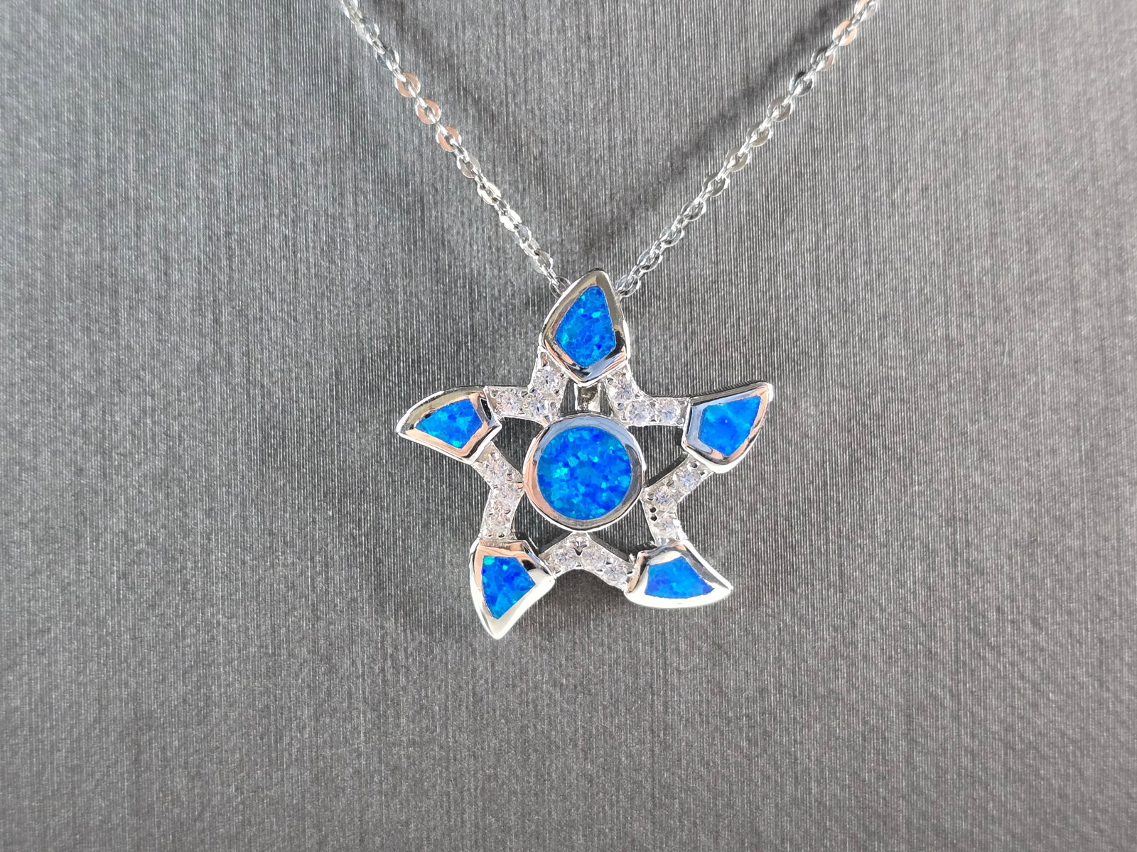 Womens Sterling Silver Starfish Blue Opal Pendant Necklace: A WOMENS STERLING SILVER STARFISH BLUE OPAL PENDANT WITH NECKLACE. THE PENDANT AND NECKLACE TOGETHER WEIGH 5.0g. THE NECKLACE MEASURES 18", AND THE PENDANT MEASURES 7/8" LONG BY 7/8" WIDE. NOT SURE IF