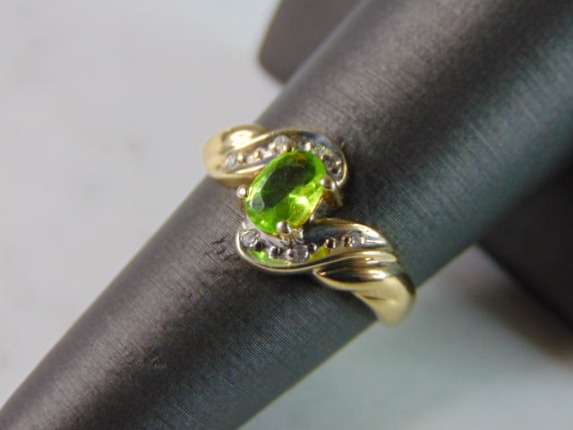 Womens Vintage Estate 10K Yellow Gold Peridot Diamond Ring: A WOMENS VINTAGE ESTATE 10K YELLOW GOLD PERIDOT DIAMOND RING. THE TOTAL WEIGHT IS 2.3g. THE RING SIZE IS A 7.0. THE STONE IS ABOUT .50cts, AND THE TOTAL DIAMONDS WEIGHT IS ABOUT .06. RING IS MARKED 10