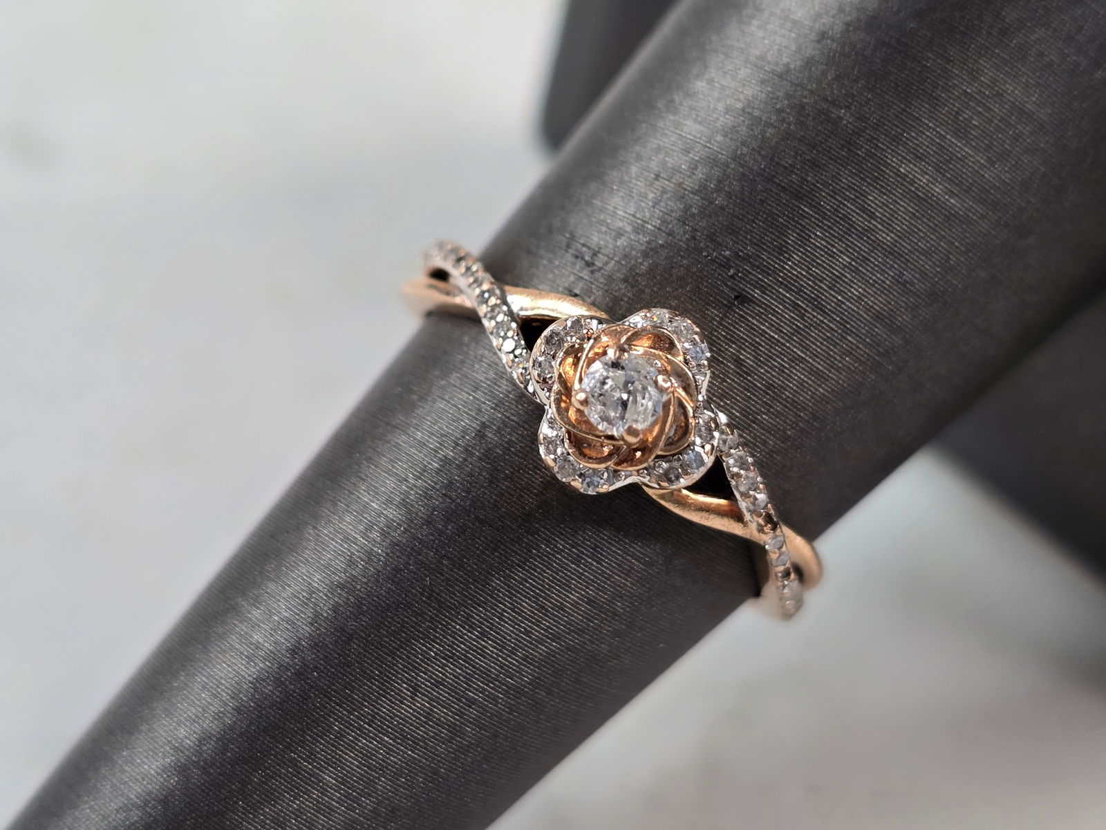 Womens Vintage Estate 10K Rose Gold Diamond Ring: A WOMENS VINTAGE ESTATE 10K ROSE GOLD DIAMOND RING. THE RING WEIGHS 2.5g, AND IS A SIZE 7.0. THE WIDTH OF THE RING IS 5/16". THERE ARE ABOUT 38 SMALL DIAMONDS IN THIS RING, WITH THE CENTER BEING ABOUT