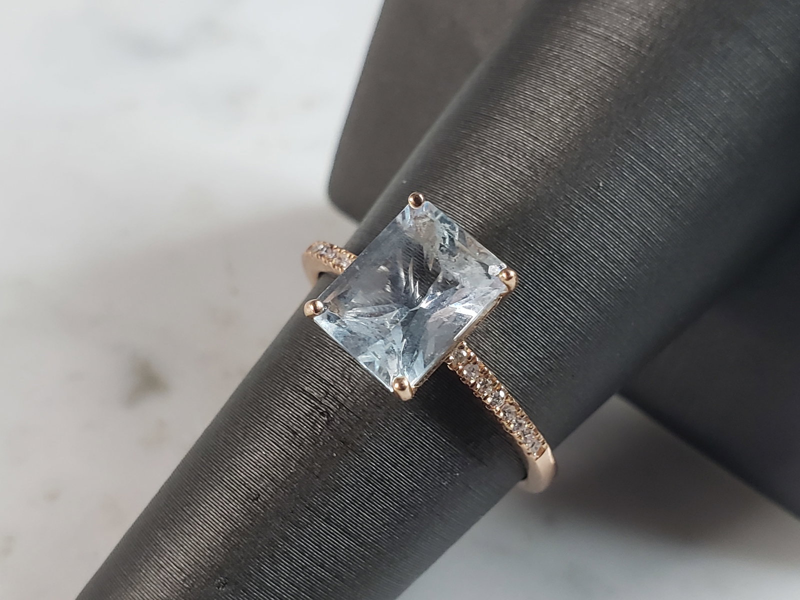 Womens Vintage Estate 14K Rose Gold Aqua & Diamond Ring: A WOMENS VINTAGE ESTATE 14K ROSE GOLD RING WITH A BLUE AQUA COLORED STONE SURROUNDED BY ABOUT .08cts OF DIAMONDS. THE RING WEIGHS 2.5g, AND IS A SIZE 8.0. RING IS STAMPED "14K". TOPAZ STONE IS NOT REA