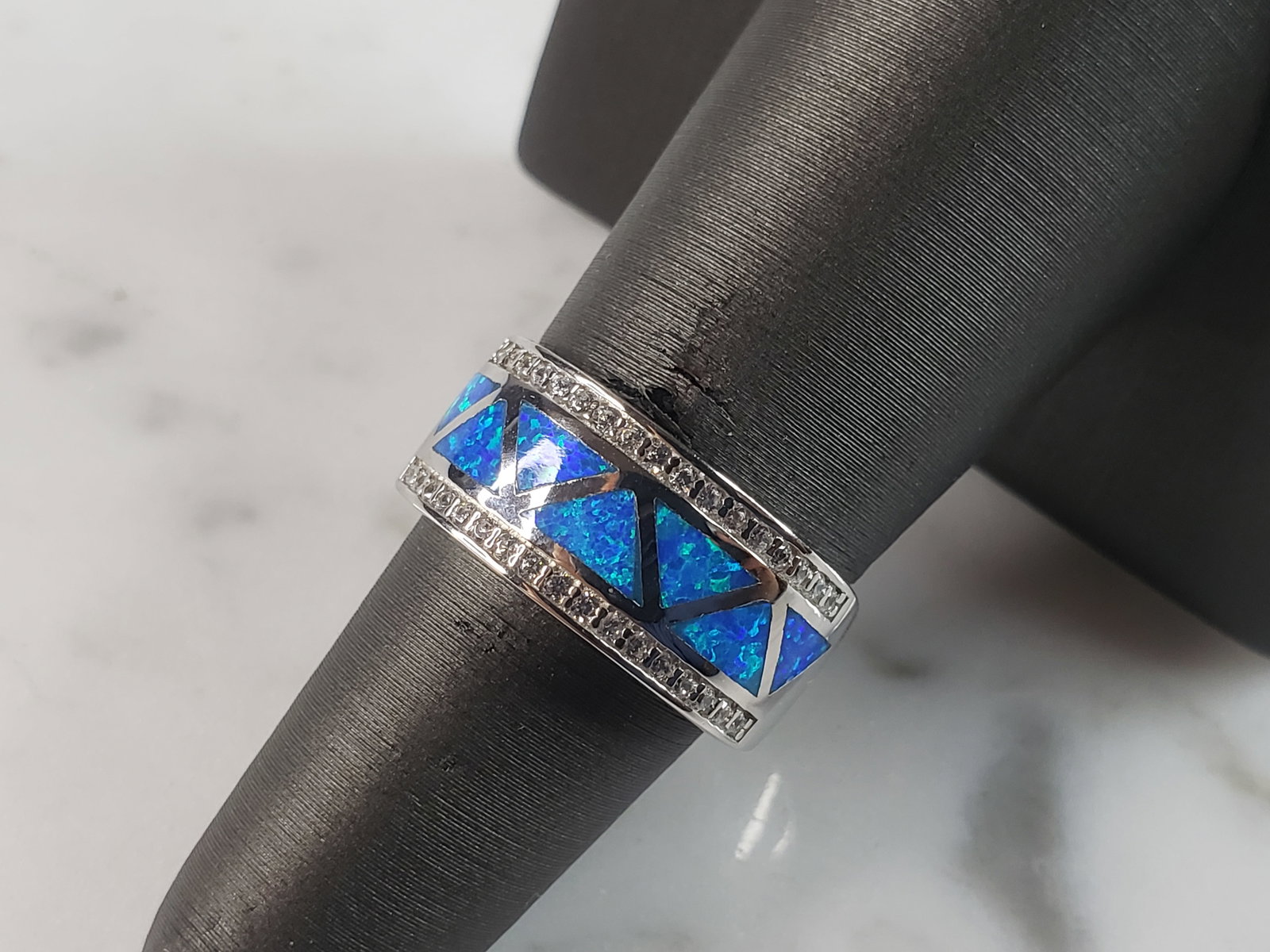 Womens Estate Sterling Silver Modernist Blue Opal & CZ Ring: A WOMENS ESTATE STERLING SILVER MODERNIST BLUE OPAL COLORED RING. THE RING IS A SIZE 6.25 AND WEIGHS 5.2g. WIDTH OF RING MEASURES 3/8". NOT SURE IF STONE IS NATURAL OR MAN MADE. THE RING MAKES A BEAUT