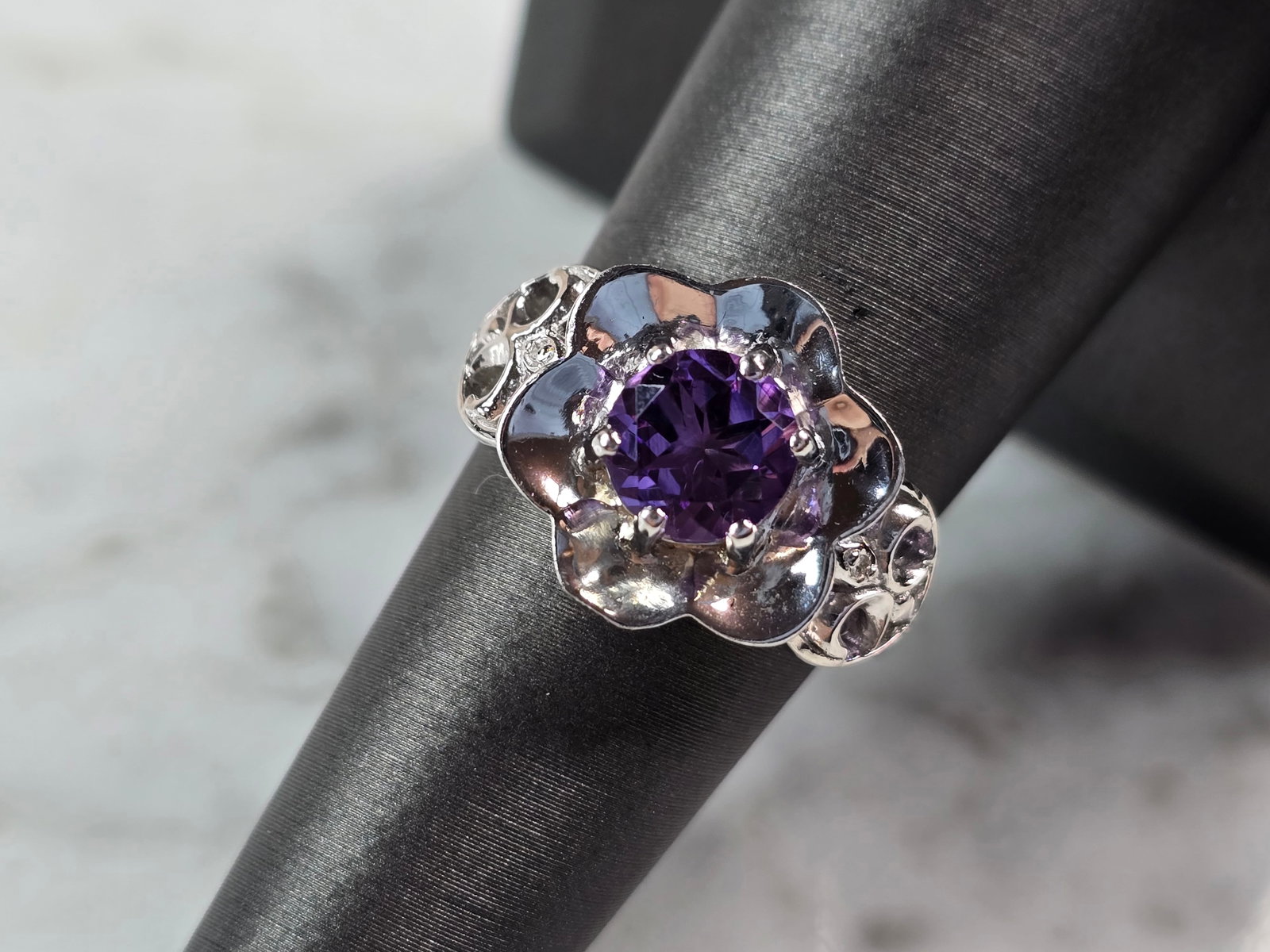 Womens Estate Sterling Silver Floral Amethyst Ring: A LOVELY WOMENS ESTATE STERLING SILVER FLORAL AMETHYST RING. RING SIZE IS 6.75, AND WEIGHS 6.2g. THE WIDTH OF THE RING IS 5/8". NOT SURE IF THE STONE IS NATURAL OR MAN MADE. THIS WOULD MAKE A NICE GIF