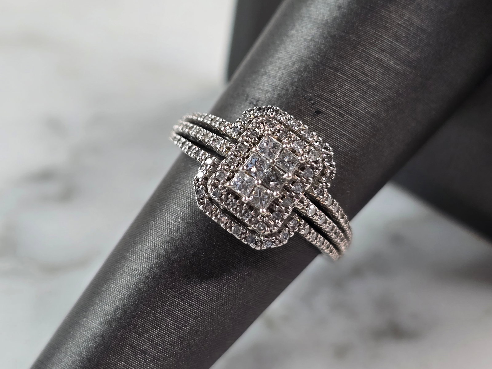 Womens Vintage Estate 10K White Gold Diamond Keepsake Ring: A WOMENS VINTAGE ESTATE 10K WHITE GOLD DIAMOND KEEPSAKE RING. THE RING IS A SIZE 7.25, AND WEIGHS 3.3g. RING HAS A CNETER DIAMOND OF ABOUT 0.20cts, SURROUNDED BY 66 TINY DIAMONDS. THE WIDTH OF THE RIN