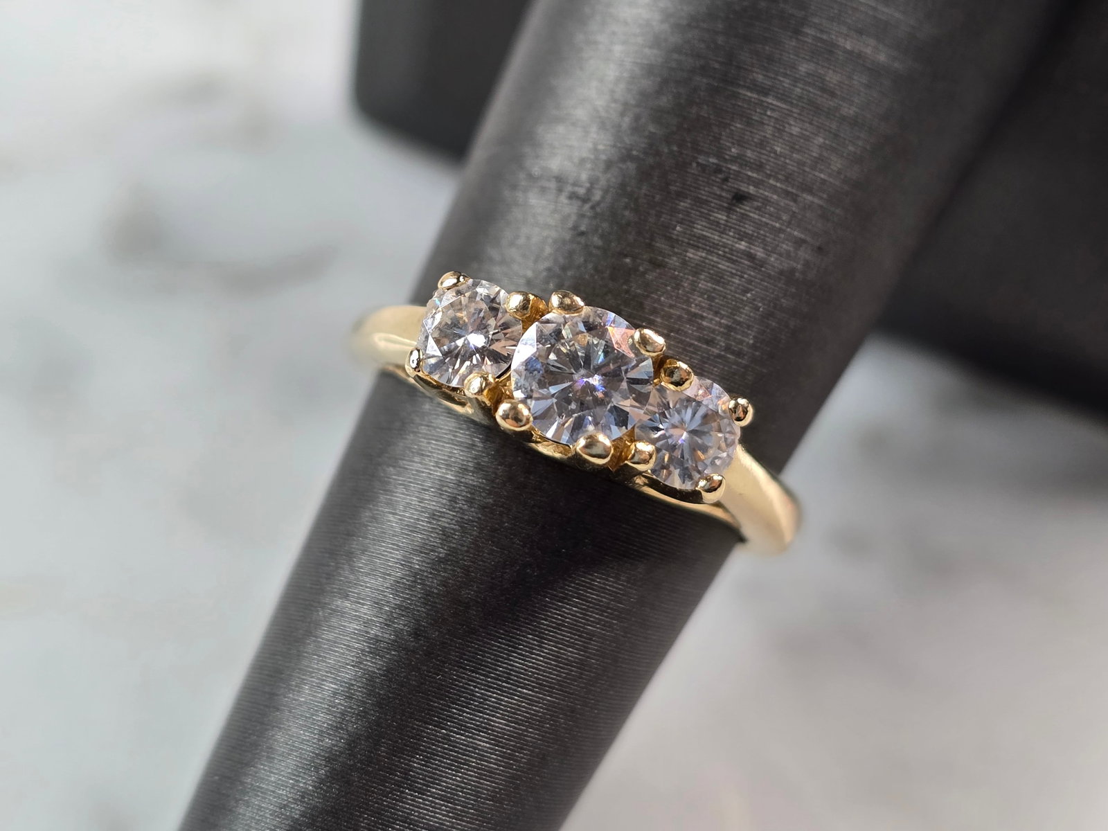 Womens Vintage Estate 14k Yellow Gold Moissanite Ring: A WOMENS VINTAGE ESTATE 14K GOLD MOISSANITE RING. THE RING IS A SIZE 6.5 AND WEIGHS 3.6g. ONE OF THE STONES HAS A SMALL CHIP. RING IS MARKED ON THE INSIDE OF THE BAND. THE RING MAKES A BEAUTIFUL, IMPR