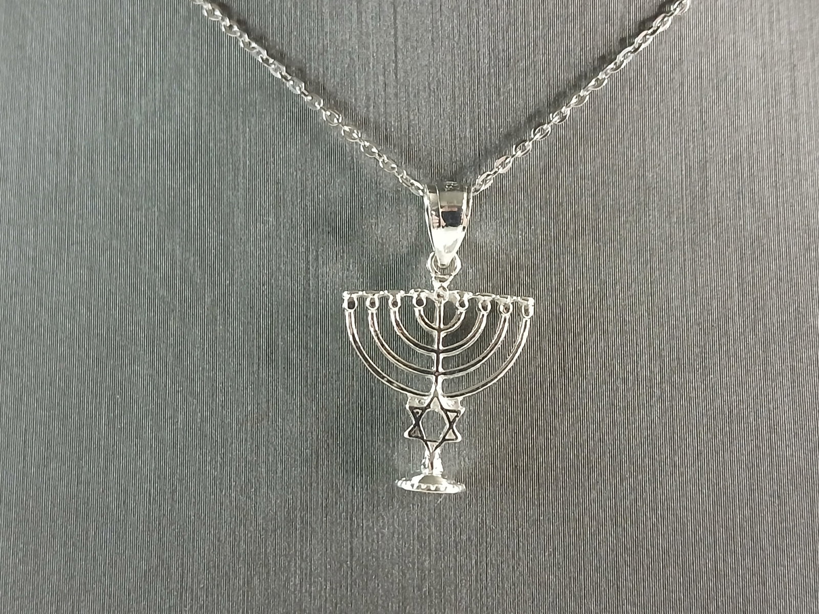 Womens Sterling Silver Jewish Judaica Hebrew Menorah Pendant Necklace: A WOMENS STERLING SILVER JEWISH HEBREW MENORAH PENDANT NECKLACE. PENDANT WITH NECKLACE WEIGHS 2.3g. THE PENDANT MEASURES 1" LONG BY 5/8" WIDE. THE NECKLACE MEASURES 18" LONG AND IS ADJUSTABLE TO 16".