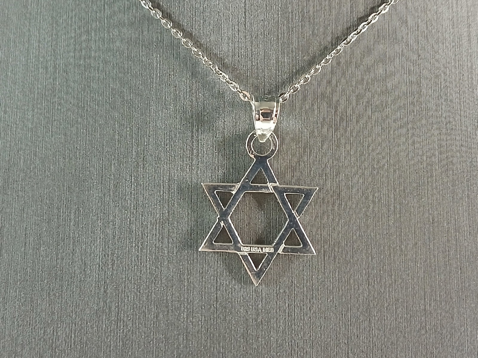 Sterling Silver Jewish Judaica Star of David Pendant Necklace: A STERLING SILVER STAR OF DAVID PENDANT WITH NECKLACE. THE PENDANT WITH NECKLACE WEIGHS 3.0g. THE NECKLACE MEASURES 18" LONG, AND IS ADJUSTABLE TO 16" LONG. THE PENDANT MEASURES 1" LONG BY 3/4" WIDE.