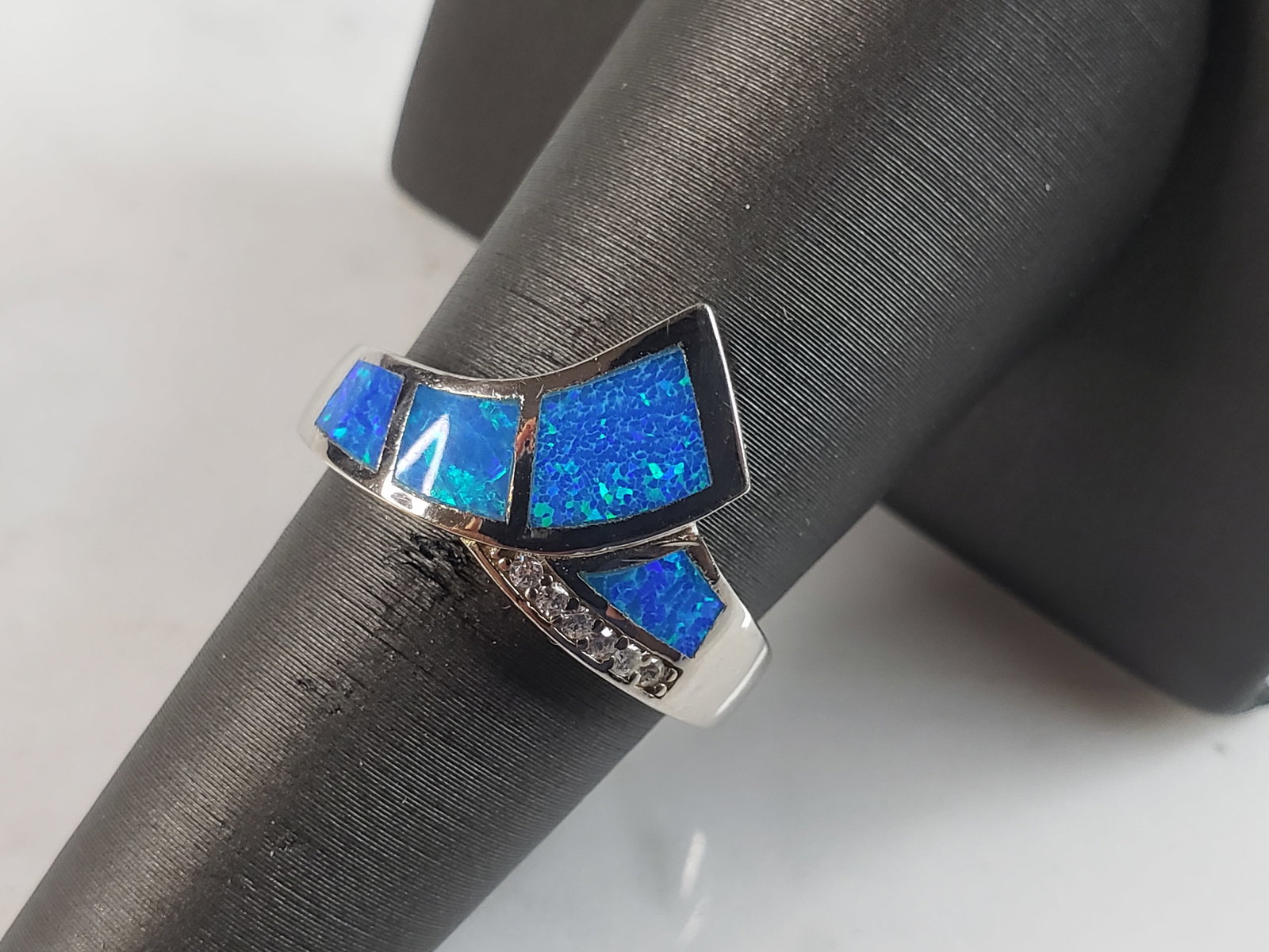 Womens Estate Sterling Silver Modernist Blue Opal & CZ Ring: A WOMENS ESTATE STERLING SILVER MODERNIST BLUE OPAL COLORED RING. THE RING IS A SIZE 6.0 AND WEIGHS 4.8g. WIDTH OF RING MEASURES 1/2". NOT SURE IF STONE IS NATURAL OR MAN MADE. THE RING MAKES A BEAUTI