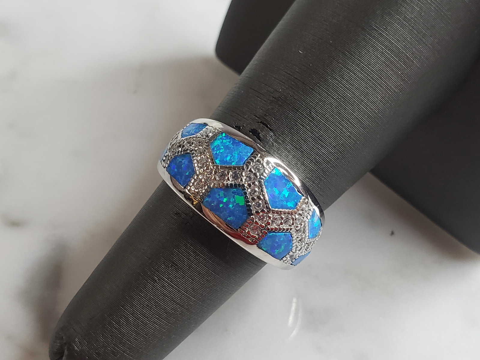 Womens Estate Sterling Silver Modernist Blue Opal & CZ Ring: A WOMENS ESTATE STERLING SILVER MODERNIST BLUE OPAL COLORED RING. THE RING IS A SIZE 7.0 AND WEIGHS 5.5g. WIDTH OF RING MEASURES 3/8". NOT SURE IF STONE IS NATURAL OR MAN MADE. THE RING MAKES A BEAUTI