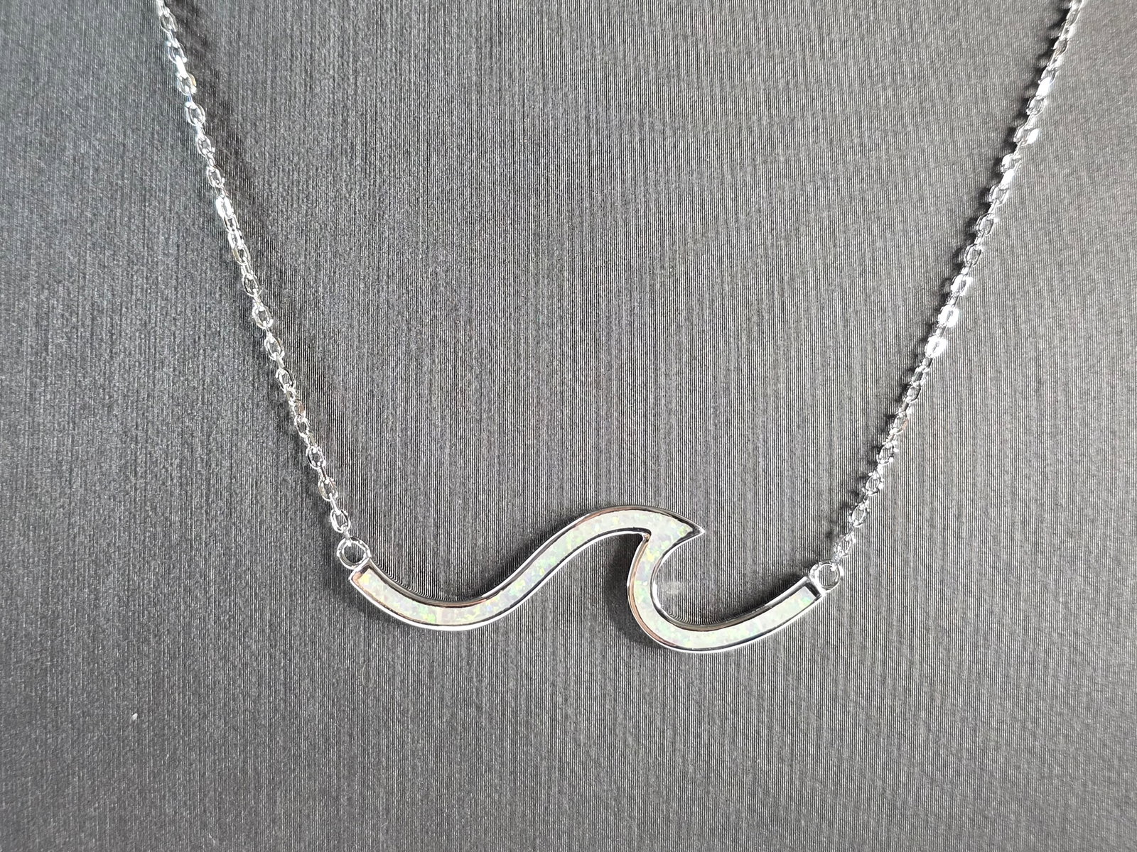 Womens Sterling Silver Opal Tsunami Wave Pendant Necklace: A WOMENS STERLING SILVER OPAL TSUNAMI WAVE PENDANT. THE PENDANT WITH NECKLACE WEIGHS 4.0g. THE PENDANT MEASURES 1 5/8" LONG BY 1/2" WIDE, AND THE NECKLACE MEASURES 18" LONG. NOT SURE IF STONES ARE NAT