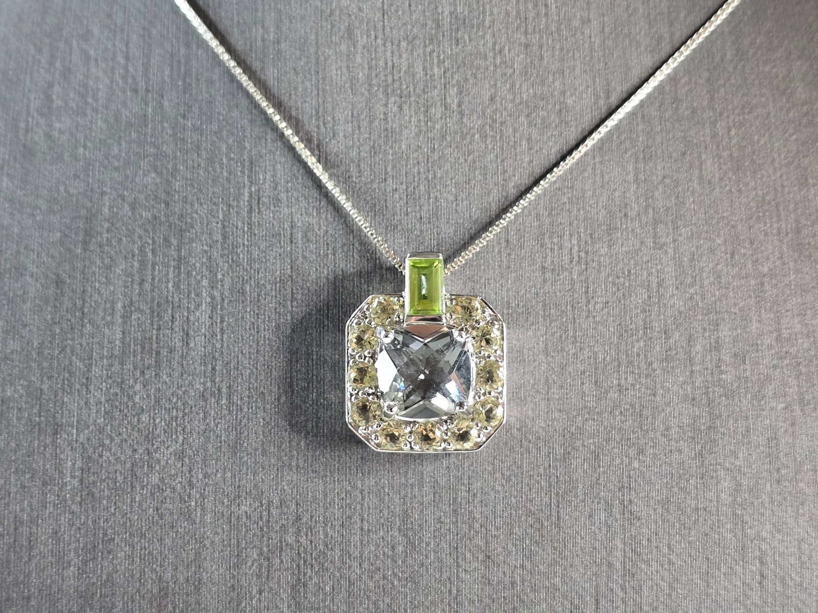 Womens Vintage Estate Sterling Silver CZ Peridot Pendant Necklace: A WOMENS VINTAGE ESTATE STERLING SILVER CZ, PERIDOT COLORED PENDANT NECKLACE. NOT SURE IF THE STONES IS NATURAL OR MAN MADE. THE TOTAL WEIGHT IS 9.0g. NECKLACE MEASURES 18" LONG, AND THE PENDANT IS 7/