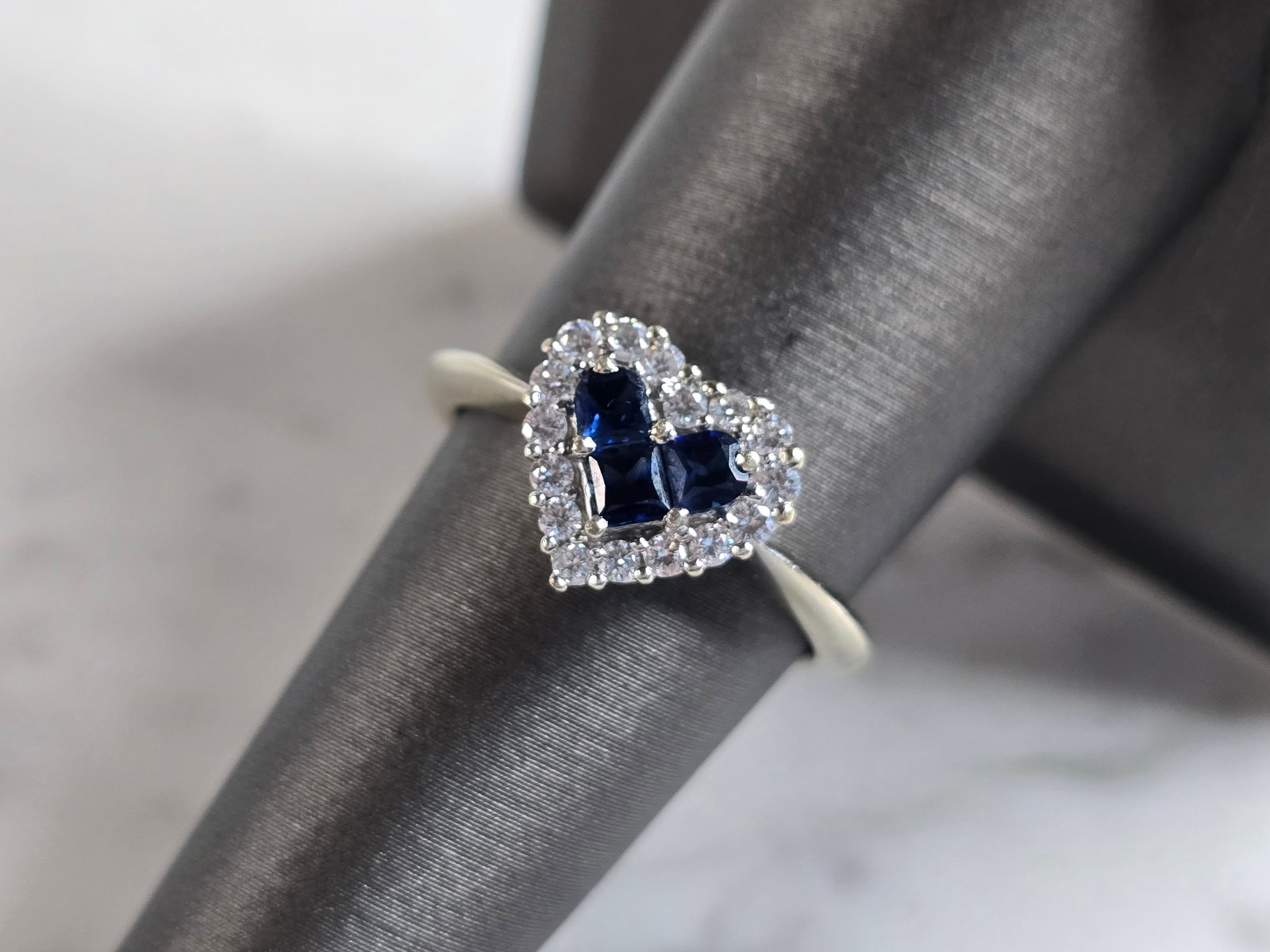 Womens Vintage Estate 14K White Gold Diamond Sapphire Heart Ring: A WOMENS VINTAGE ESTATE 14K WHITE GOLD DIAMOND SAPPHIRE HEART RING. THE RING WEIGHS 3.3g, AND IS A SIZE IS 7.0. THERE ARE ABOUT .16cts OF DIAMONDS. WIDTH OF THE RING IS 3/8". RING IS MARKED 14K. ANY Q