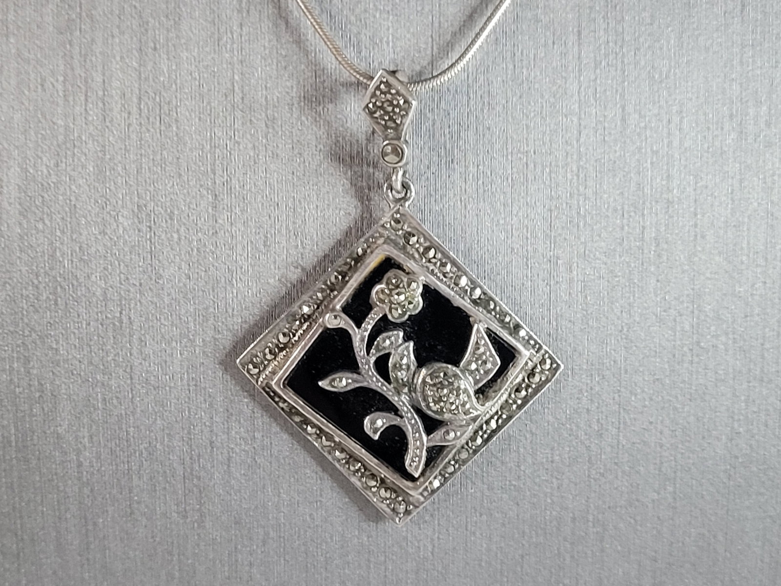 Womens Vintage Estate Sterling Silver Necklace w/ Floral Pendant: A WOMENS VINTAGE ESTATE STERLING SILVER NECKLACE WITH A FLORAL PENDANT. TOGETHER THEY WEIGH 14.1g. THE NECKLACE MEASURES 20" LONG. THE PENDANT MEASURES 2" LONG BY 1 3/8" WIDE. THIS WOULD MAKE A NICE G