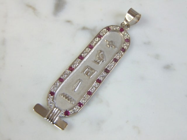Vintage Estate 18K White Gold Egyptian Pendant: A WOMENS VINTAGE ESTATE 18K WHITE GOLD EGYPTIAN PENDANT. THE PENDANT MEASURES 2 1/2" BY 5/8", AND WEIGHS 7.1g. THE STONES ARE RUBIES AND DIAMONDS. THERE ARE ABOUT .16cts OF EACH. PENDANT IS NOT MARKED