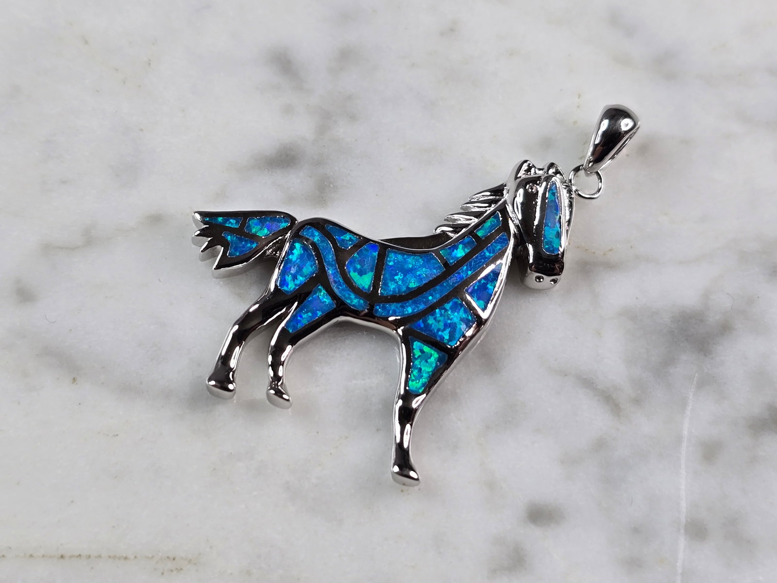 Womens Sterling Silver Blue Opal Horse Pendant: A WOMENS STERLING SILVER BLUE OPAL HORSE PENDANT. THE PENDANT WEIGHS 6.9g, AND MEASURES 1 1/4" BY 1 1/8". NOT SURE IF STONES ARE NATURAL OR MAN MADE. MAKES A GREAT GIFT FOR THAT SOMEONE SPECIAL. ANY Q