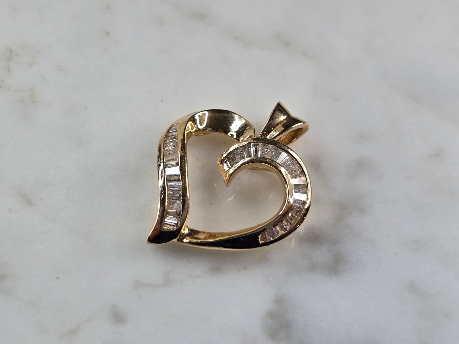 Womens Vintage Estate 14K Yellow Gold Diamond Heart Pendant: A WOMENS VINTAGE ESTATE 14K YELLOW GOLD DIAMOND HEART PENDANT. THE TOTAL WEIGHT IS 3.8g. THE PENDANT MEASURES 7/8" LONG BY 3/4" WIDE. THERE ARE 36 BAGUETTE DIAMONDS IN THIS PENDANT. MAKES A GREAT GIFT