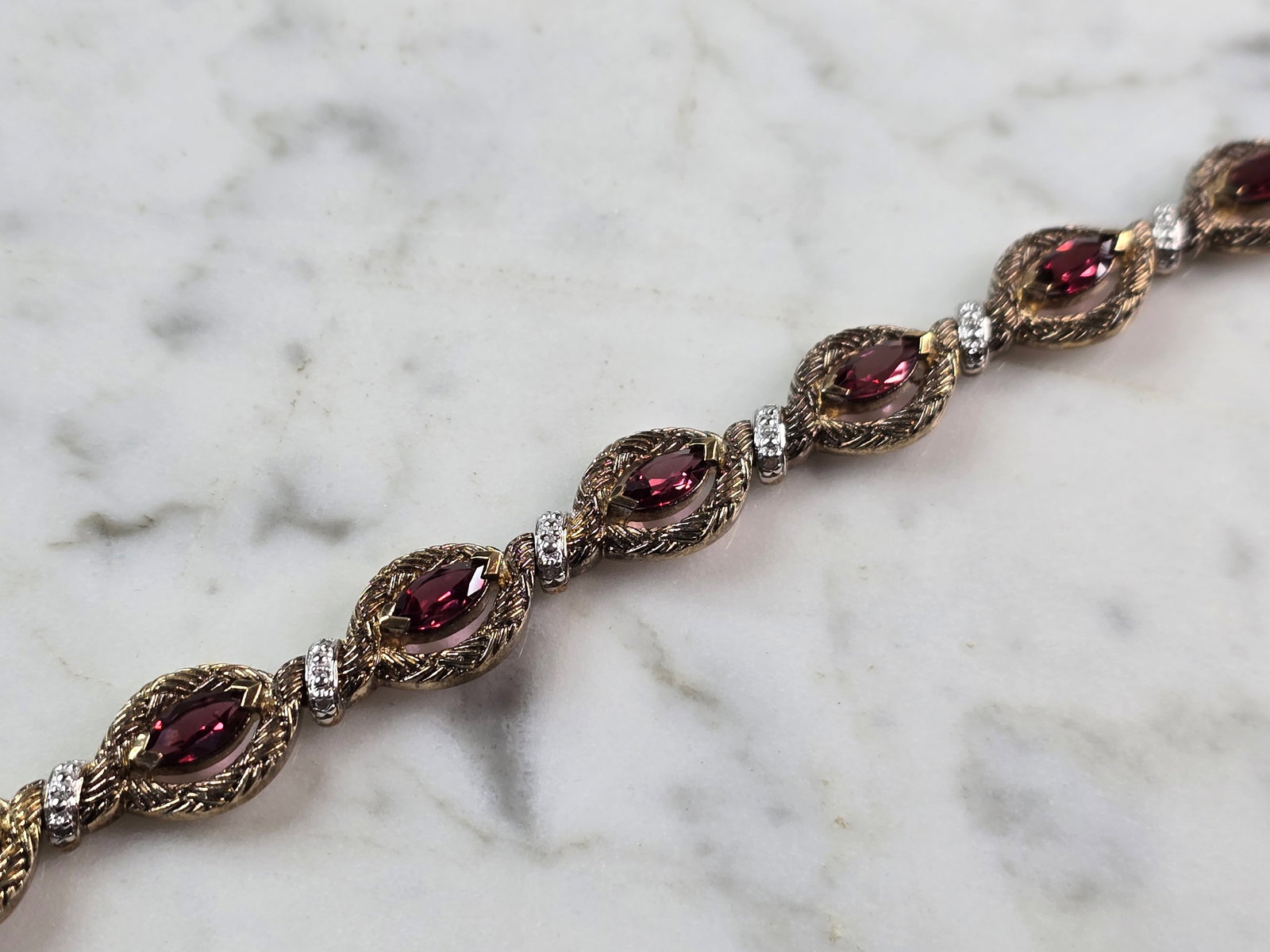 Womens Vintage Estate Sterling Silver Gold Tone Bracelet: A WOMENS VINTAGE ESTATE STERLING SILVER GOLD TONE BRACELET WITH RUBY COLORED STONES. BRACELET IS ABOUT 7 1/2" LONG BY 3/8" WIDE AND WEIGHS 17.9g. NOT SURE IF STONES ARE NATURAL OR MAN MADE. WOULD MAKE