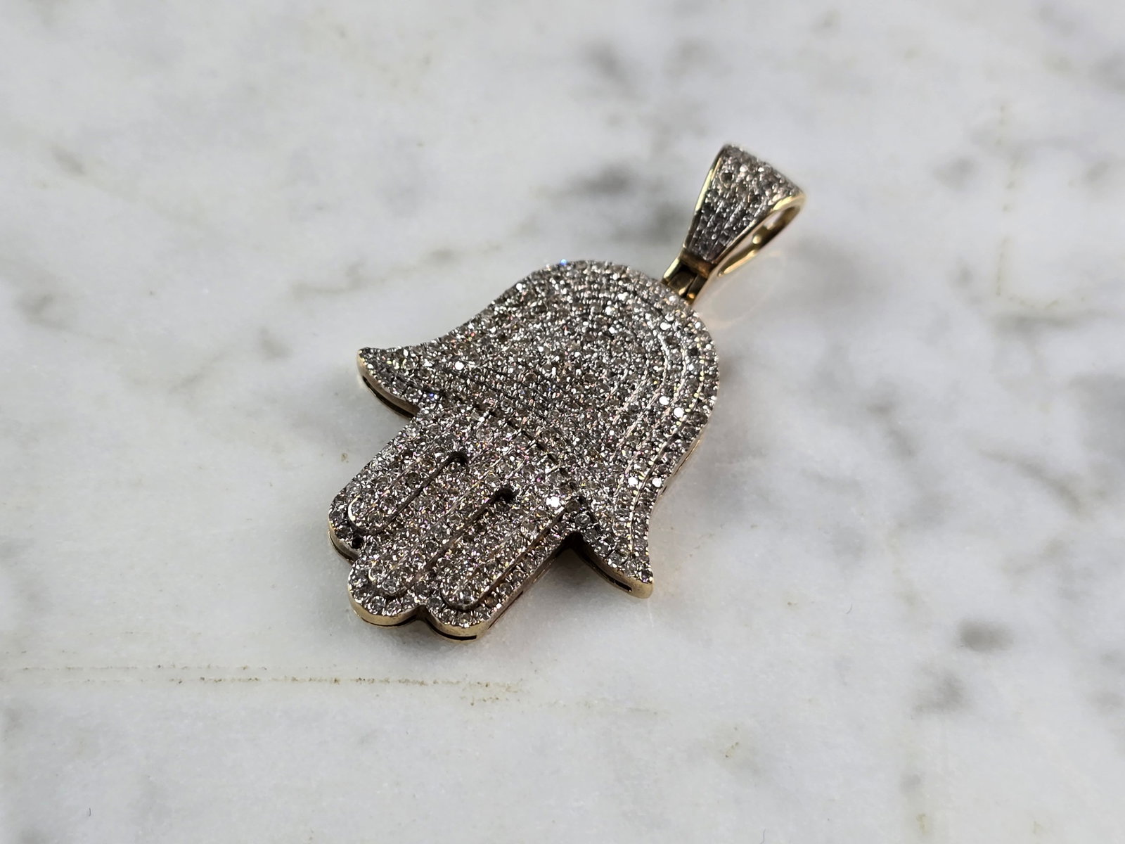 Vintage Estate 10K Gold Jewish Judaica Hamsa Pave Diamond Pendant: A VINTAGE ESTATE 10k YELLOW GOLD JUDAICA HAMSA PAVE DIAMOND PENDANT. THE PENDANT WEIGHS 5.9g, AND MEASURES 1 1/2" LONG BY 7/8" WIDE. THE PENDANT IS MARKED ON THE BACK. DIAMONDS ARE NATURAL, JUST NOT S