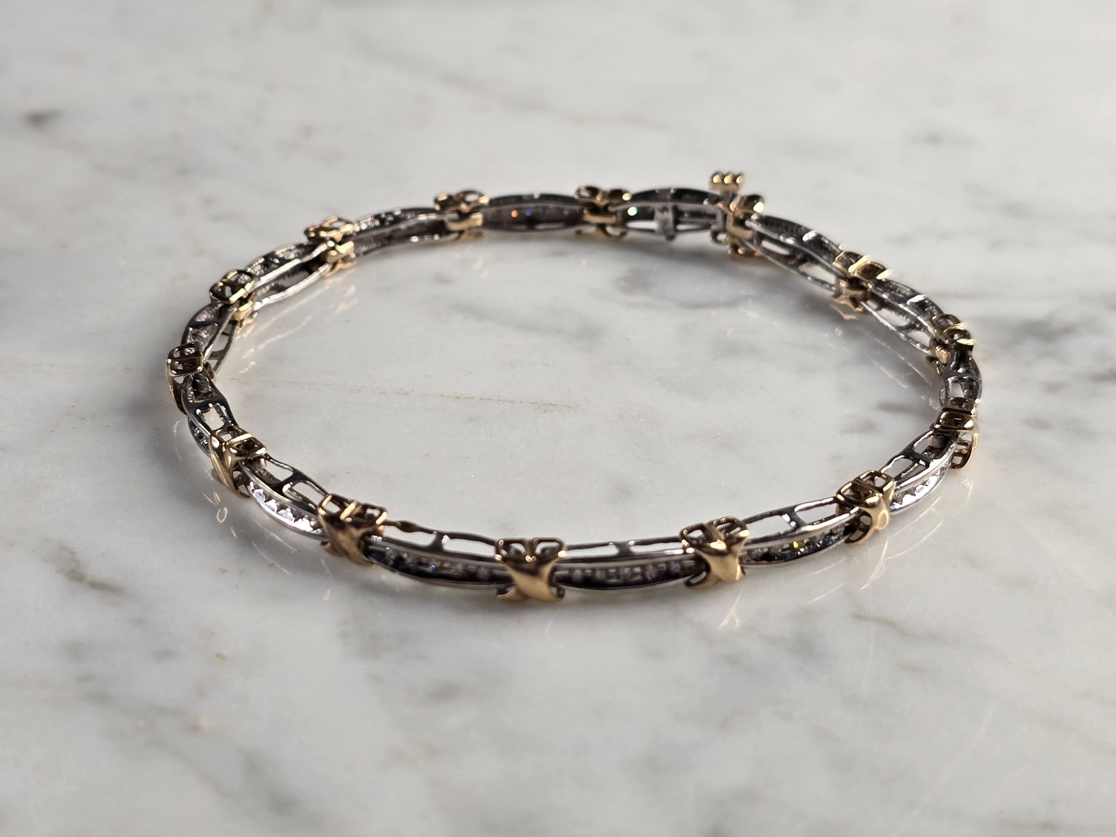 Womens Vintage Estate 10K Gold Diamond Tennis Bracelet: A LOVELY VINTAGE ESTATE 10K YELLOW & WHITE GOLD TENNIS BRACELET. THE BRACELET WEIGHS 7.6g AND MEASURES 7 1/2" LONG BY 3/16" WIDE. THERE ARE 70 SMALL DIAMONDS IN THIS BRACELET. WOULD MAKE A GREAT GIFT 