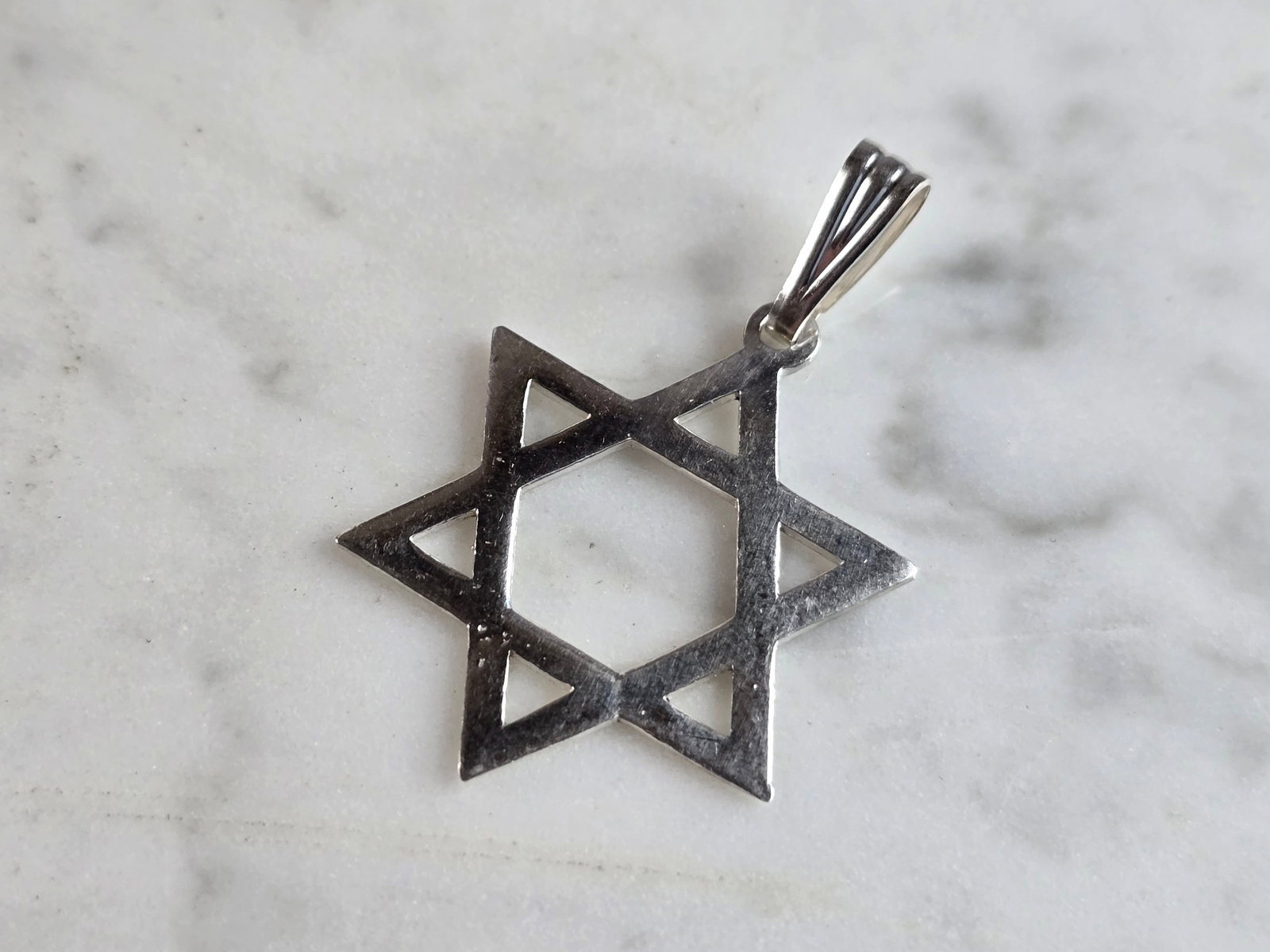 Sterling Silver Jewish Judaica Star of David Pendant: A STERLING SILVER STAR OF DAVID PENDANT. THE PENDANT WEIGHS 2.3g AND MEASURES 1 1/2" LONG BY 1" WIDE. STAMPED ON THE INSIDE OF THE BALE "925". MAKES A GREAT GIFT FOR THAT SOMEONE SPECIAL. ANY QUESTION