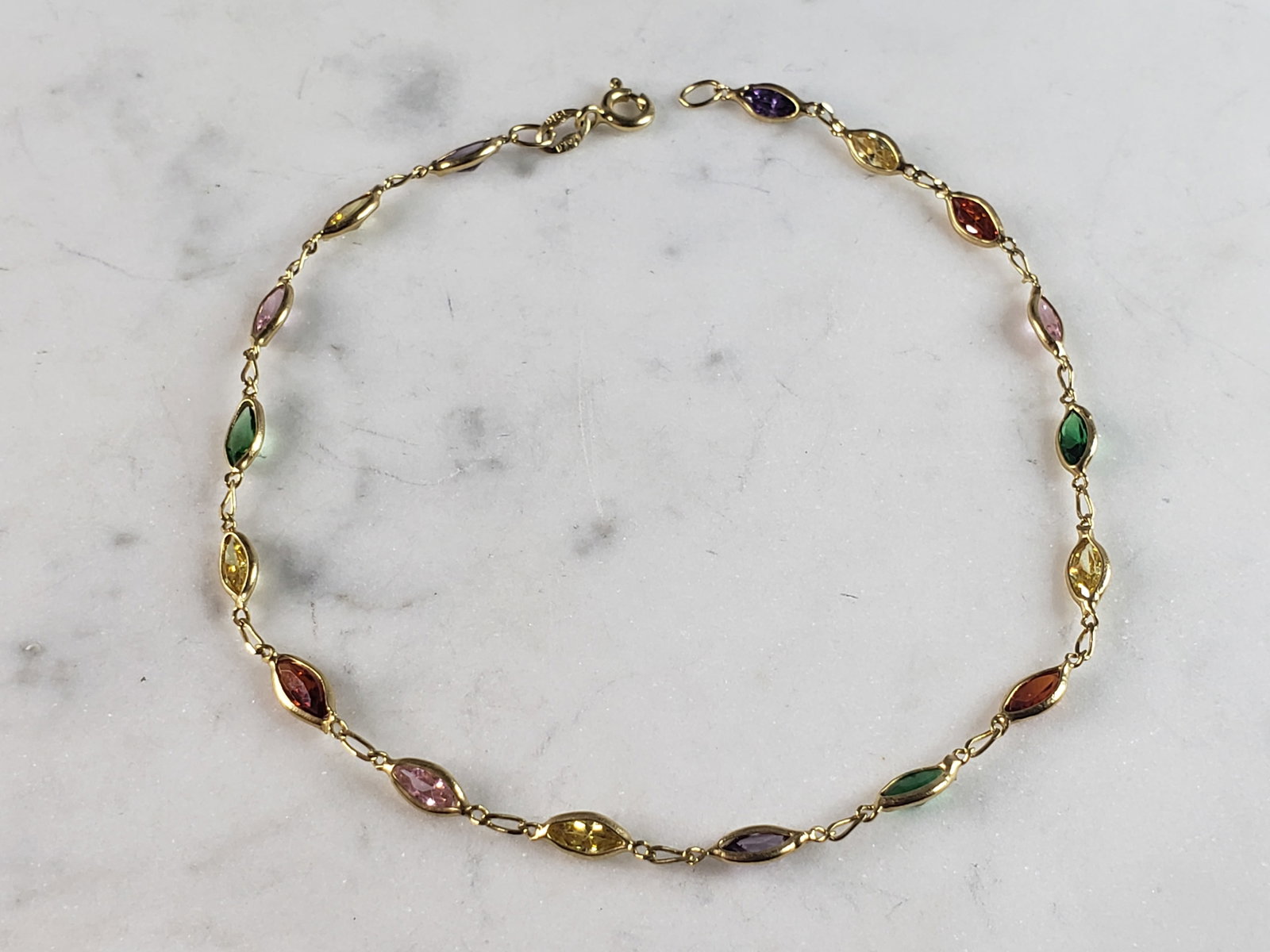 Womens Vintage Estate 14K Yellow Gold Anklet Bracelet: A WOMENS VINTAGE ESTATE 14K YELLOW GOLD ANKLET BRACELET. THE BRACELET MEASURES 8 3/4" LONG FROM THE CLASP BY 1/8" WIDE, AND WEIGHS 3.5g. BRACELET IS MARKED 14K, ITALY. THE STONES ARE FAUX. THIS WOULD 