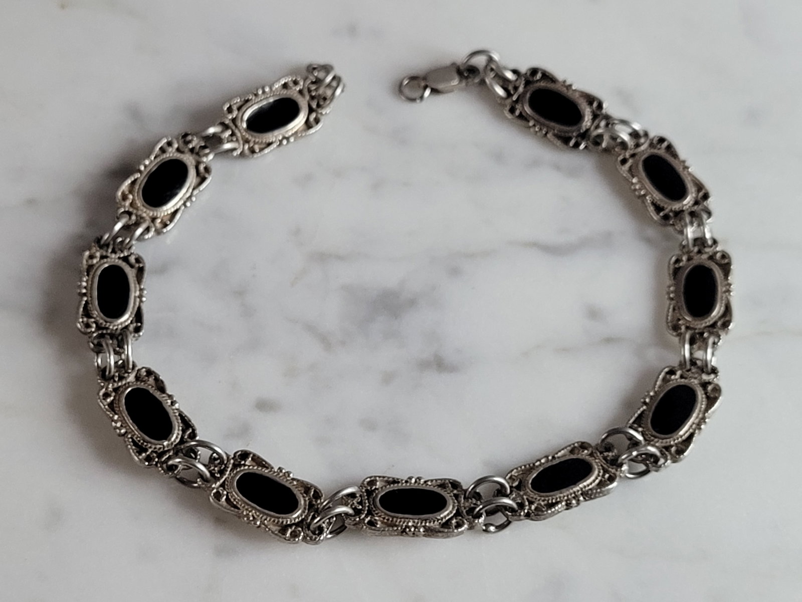 Womens Vintage Estate Sterling Silver Onyx Bracelet: FOR SALE IS A LOVELY VINTAGE ESTATE STERLING SILVER ONYX BRACELET. NOT SURE IF STONES ARE REAL OR MAN MADE. BRACELET MEASURES 8 1/2" LONG BY 5/16" WIDE AND WEIGHS 14.6g. THIS WOULD MAKE A LOVELY GIFT 