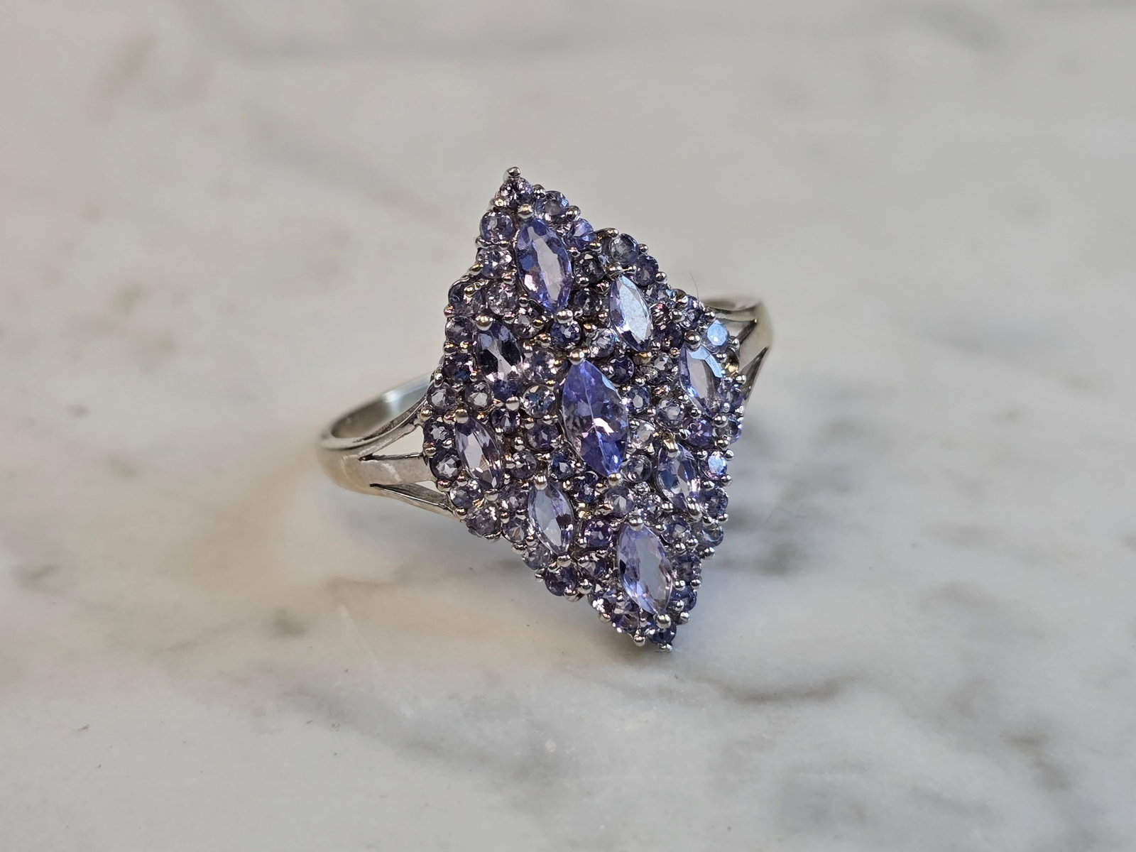 Womens Vintage Estate 10K White Gold Modernist Tanzanite Ring: A WOMENS VINTAGE ESTATE 10K WHITE GOLD MODERNIST TANZANITE RING. RING WEIGHS 3.6g, AND IS A SIZE 13.25. THE LENGTH OF THE RING IS 7/8". NOT SURE IF STONES ARE NATURAL OR MAN MADE. THIS MAKES A LOVELY 