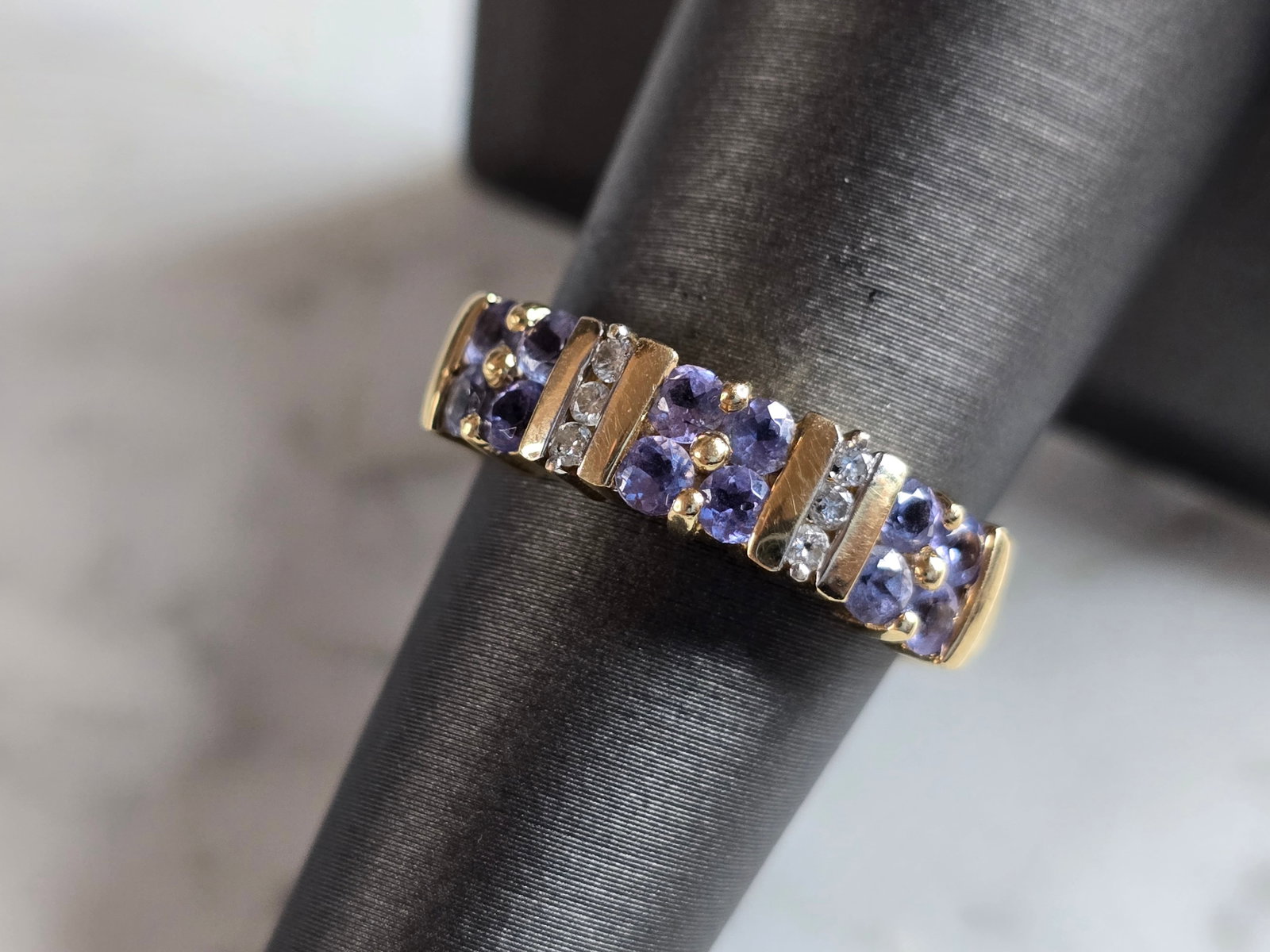 Womens Vintage Estate 14K Yellow Gold Tanzanite Diamond Ring: A WOMENS VINTAGE ESTATE 14K YELLOW GOLD TANZANITE COLORED STONE RING WITH DIAMONDS. THE RING IS A SIZE 7.25, AND WEIGHS 4.5g. THE WIDTH OF THE RING IS 1/4". RING IS STAMPED 14K ON THE INSIDE OF THE BA