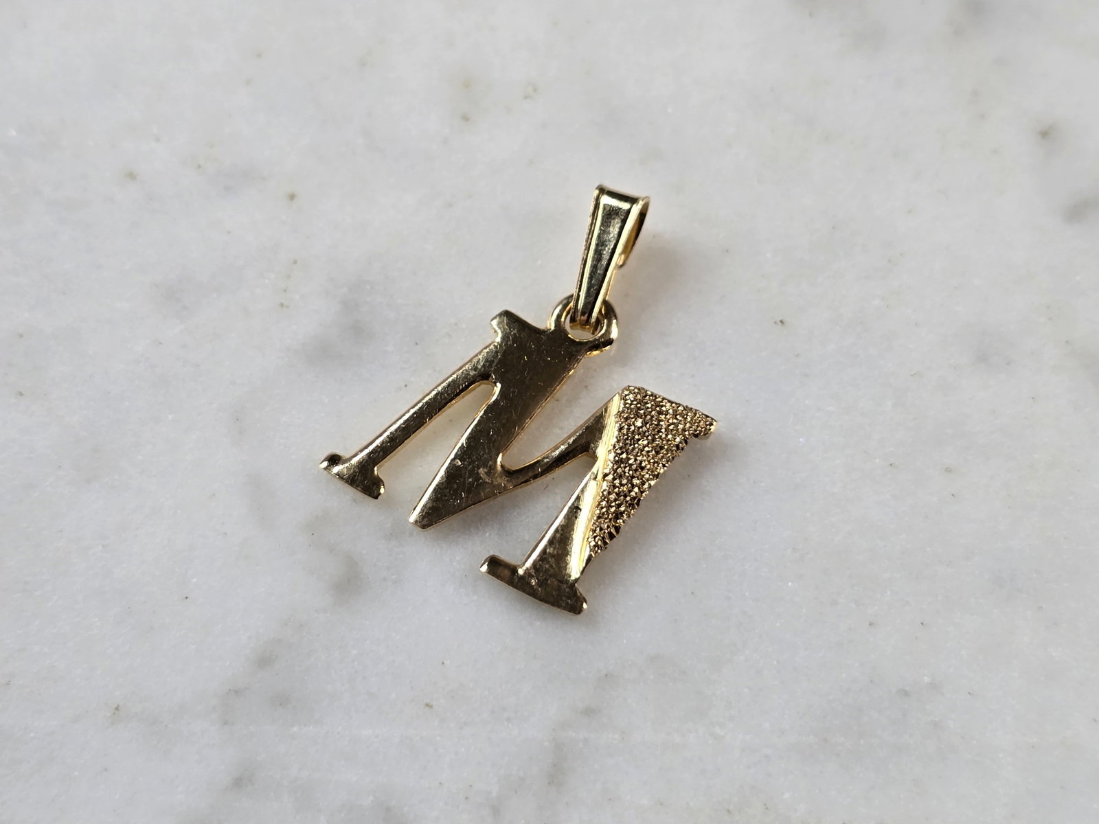 Womens Vintage Estate 10K Gold Initial Letter " M " Charm Pendant: A WOMENS VINTAGE ESTATE 10K YELLOW GOLD "M" PENDANT. PENDANT MEASURES 3/4" LONG BY 1/2" WIDE. TOTAL WEIGHT OF THE PENDANT IS 1.0g. WOULD MAKE A LOVELY GIFT FOR THAT SOMEONE SPECIAL. ANY QUESTIONS