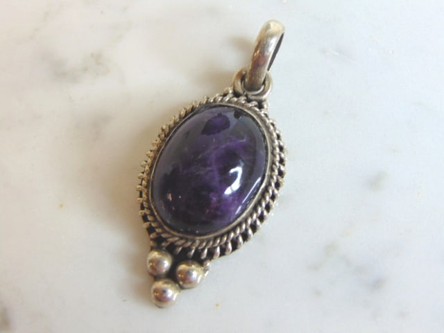 Womens Vintage Estate Sterling Silver Amethyst Pendant: A WOMENS VINTAGE ESTATE STERLING SILVER AMETHYST PENDANT. NOT SURE IF STONE IS REAL OR MAN MADE. PENDANT WEIGHS 11.4g AND PENDANT MEASURES 1 7/8" LONG BY 7/8" WIDE. MAKES A GREAT GIFT FOR THAT SOMEONE