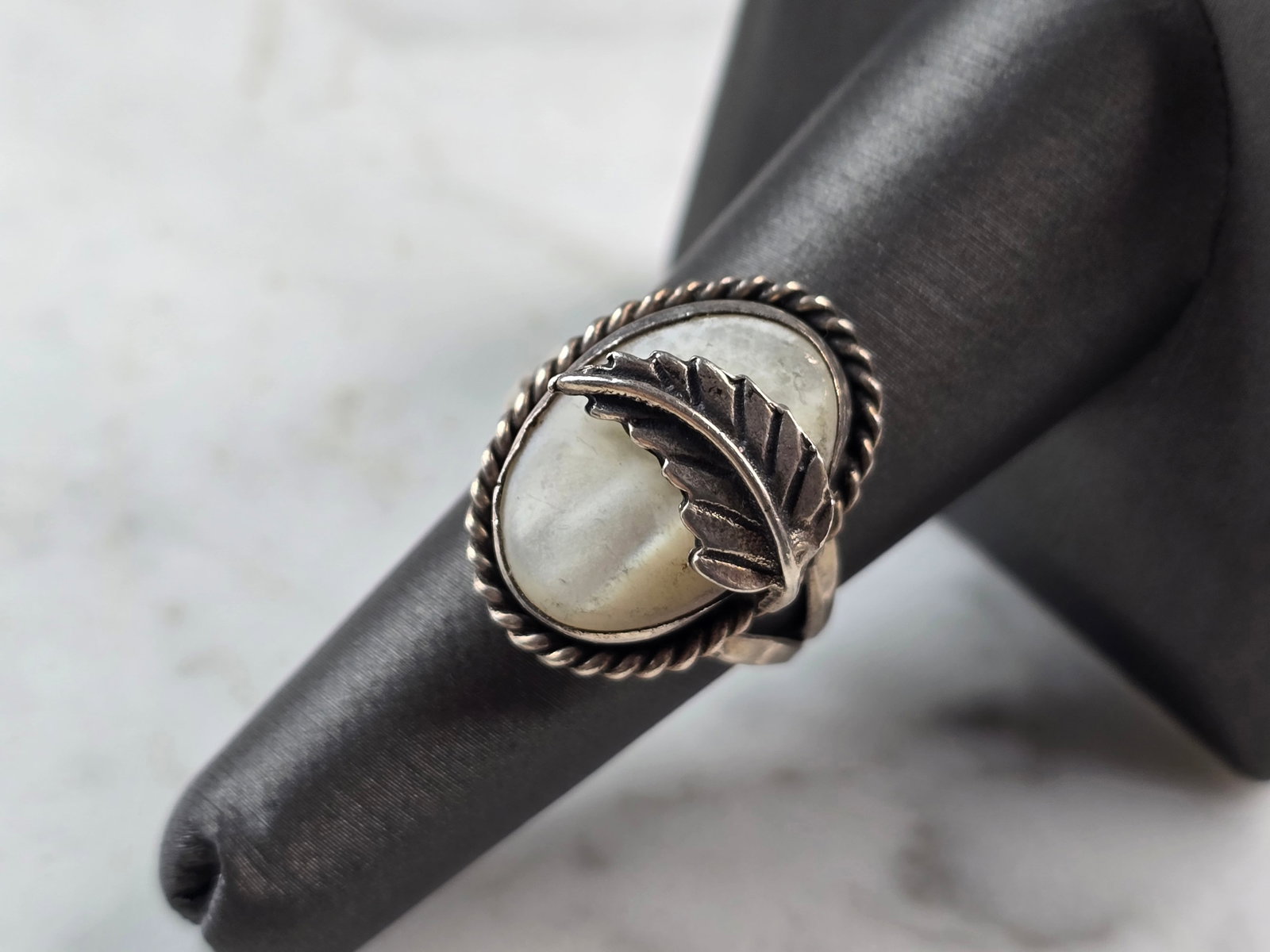 Womens Vintage Estate Sterling Silver Southwestern Style Ring: A WOMENS VINTAGE ESTATE STERLING SILVER SOUTHWESTERN STYLE RING. RING IS A SIZE 7.25, AND WEIGHS 5.7g. THE LENGTH OF THE RING IS 7/8". STONE APPEARS TO BE MOTHER OF PEARL, HOWEVER NOT SURE IF STONE IS