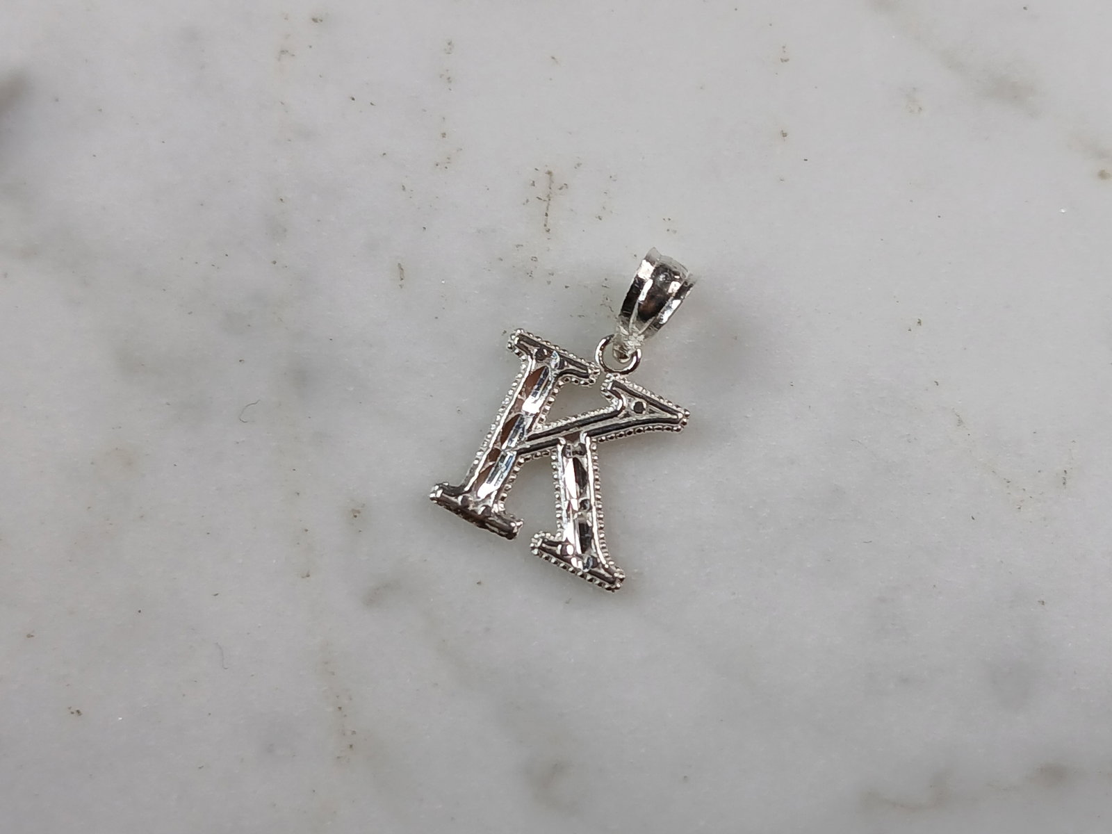 Womens Sterling Silver Initial Letter " K " Pendant: A WOMENS STERLING SILVER INITIAL LETTER "K" PENDANT. PENDANT WEIGHS 0.3g AND MEASURES 5/8" LONG BY 3/8" WIDE. MAKES A GREAT GIFT FOR THAT SOMEONE SPECIAL. ANY QUESTIONS, PLEASE ASK. BE SURE TO CHECK O